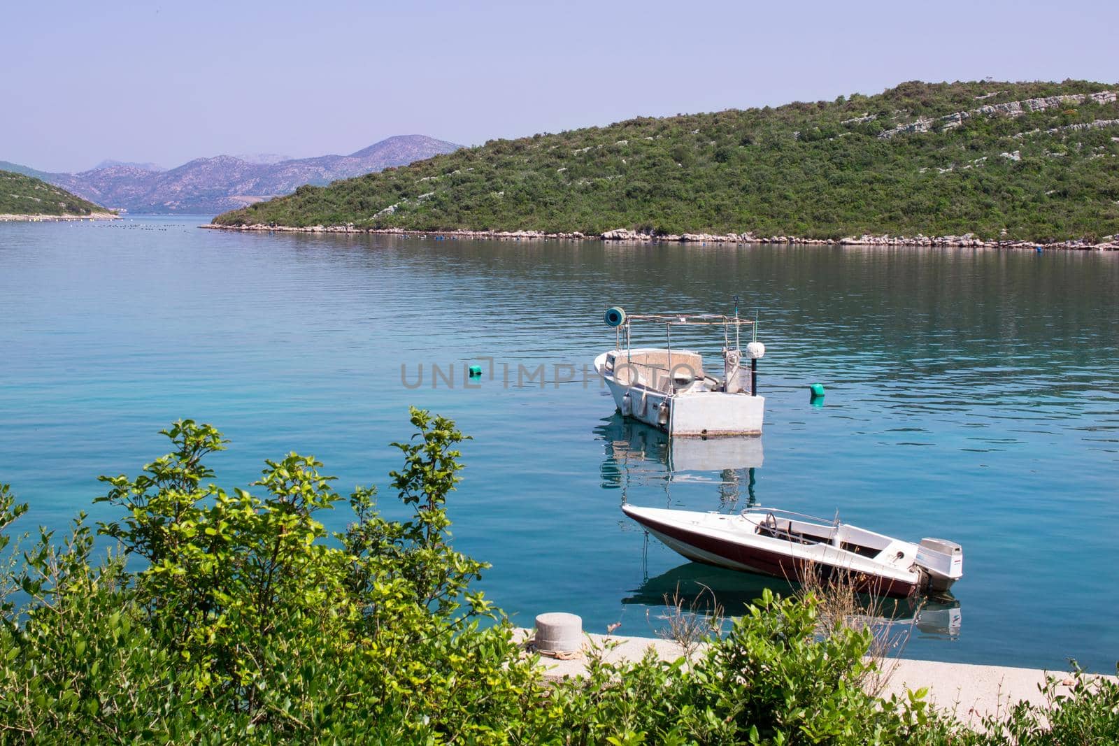 Two small fishing boats in calm waters of Adriatic sea in Croatia