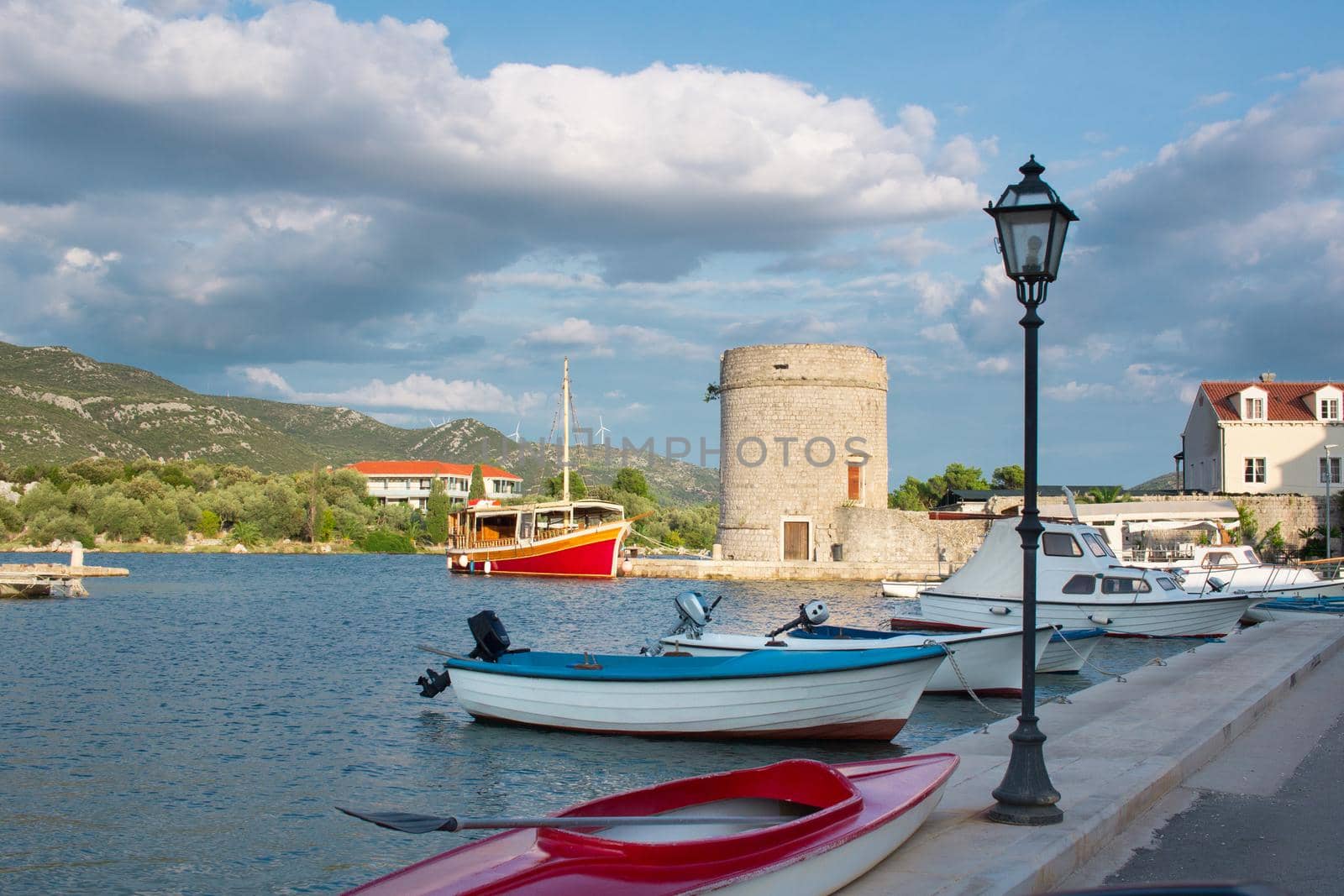 Small fishing boats in Mediterranean Adriatic sea bay tied to town quay in Croatia by VeraVerano