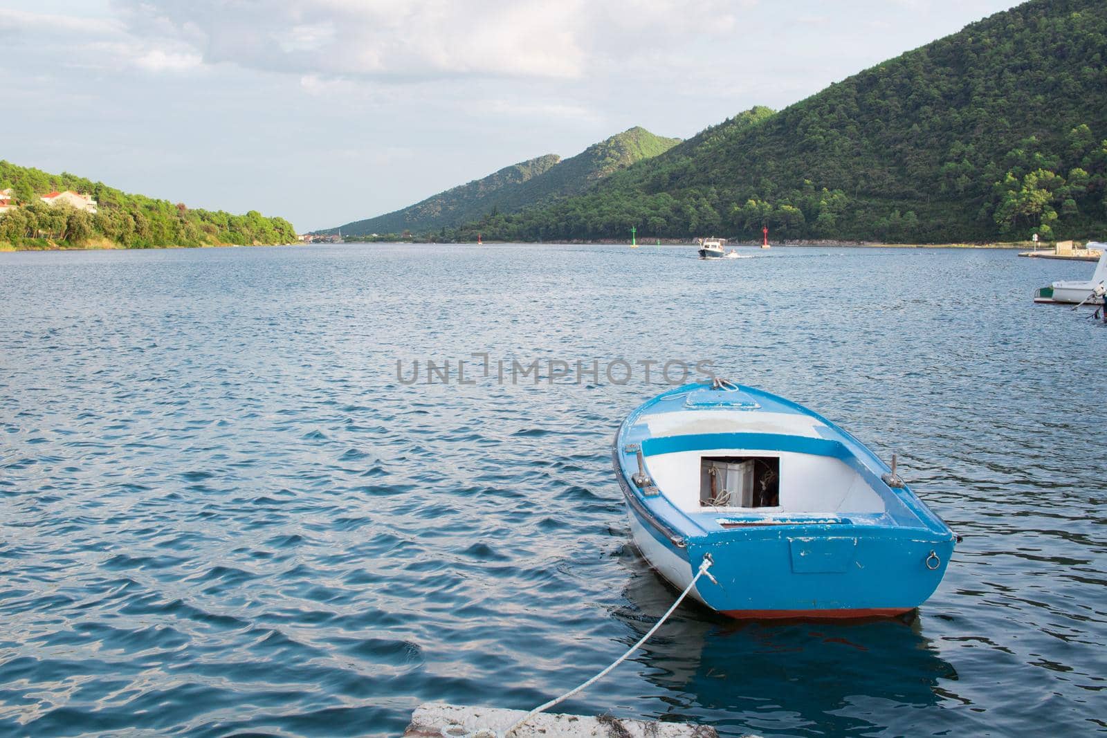 Small fishing boat in Mediterranean bay of Croatia tied to shore by VeraVerano