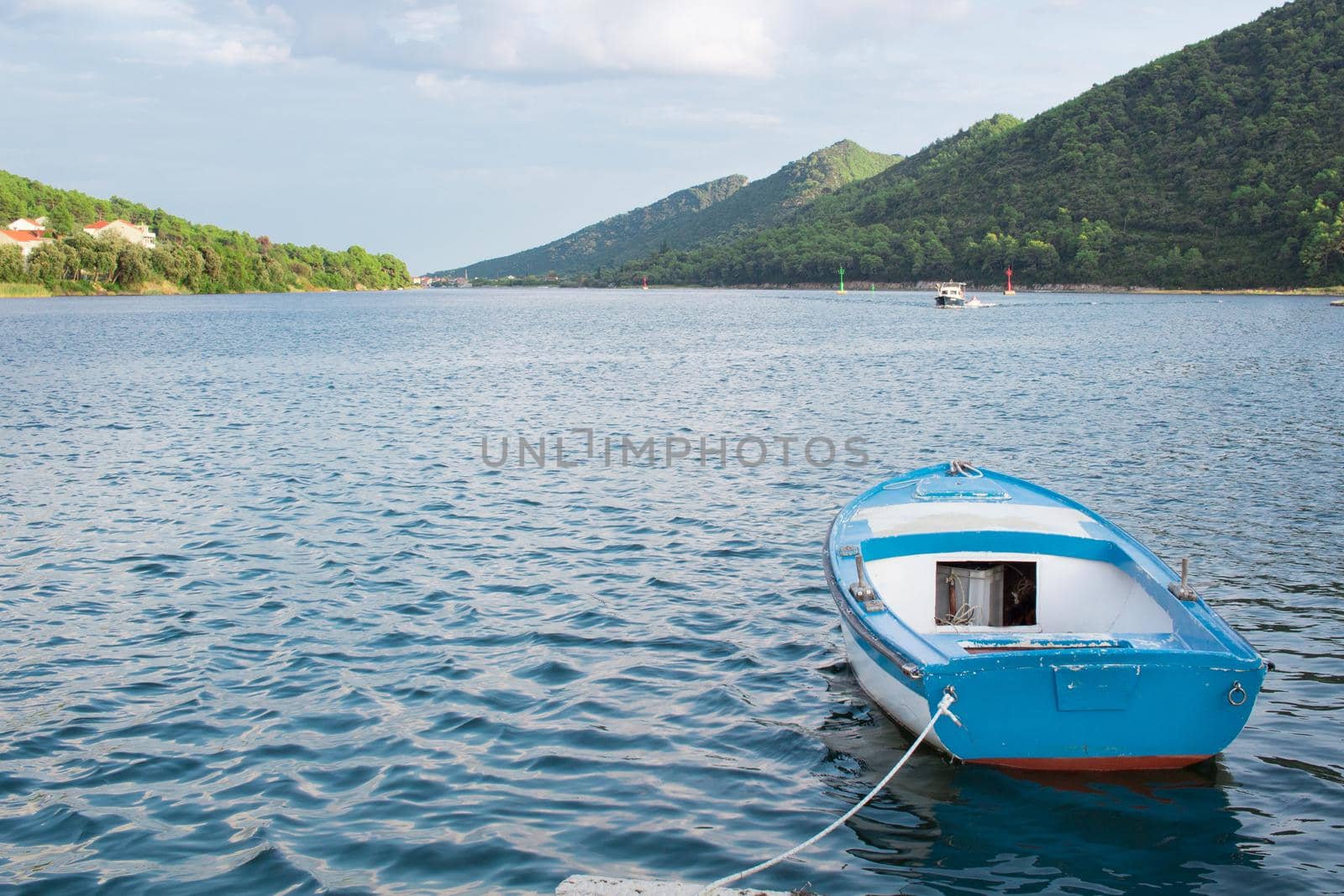 Small fishing boat in Mediterranean sea bay of Adriatic Croatia tied to shore