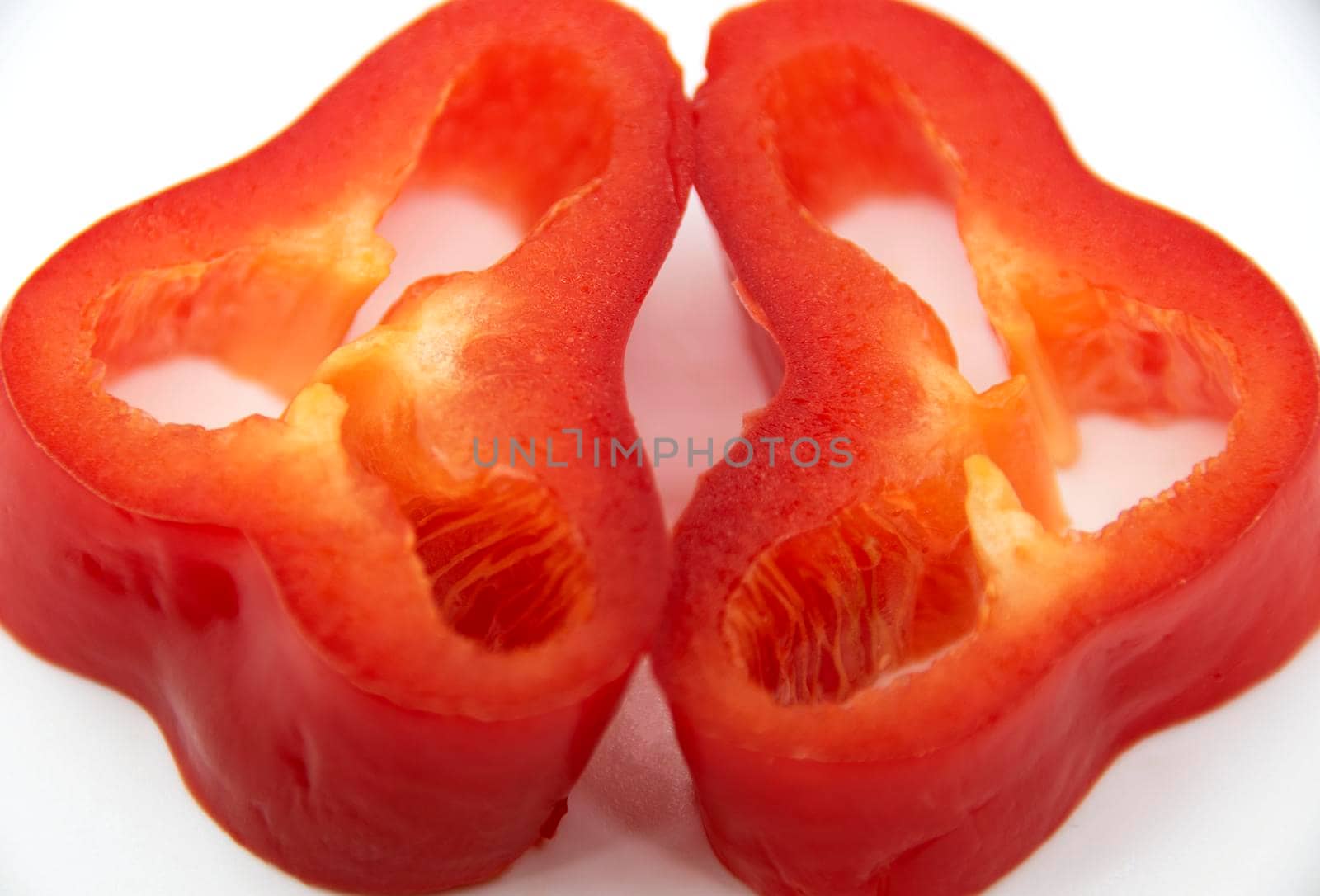 Capi of ripe juicy sweet pepper cut into rings on a white plate.