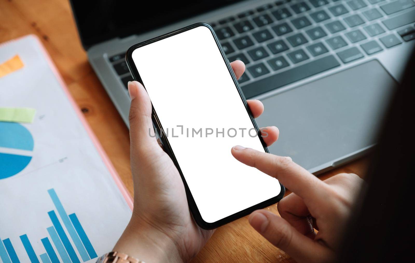 Woman holding and touch smartphone blank screen in the mall. Take your screen to put on advertising.