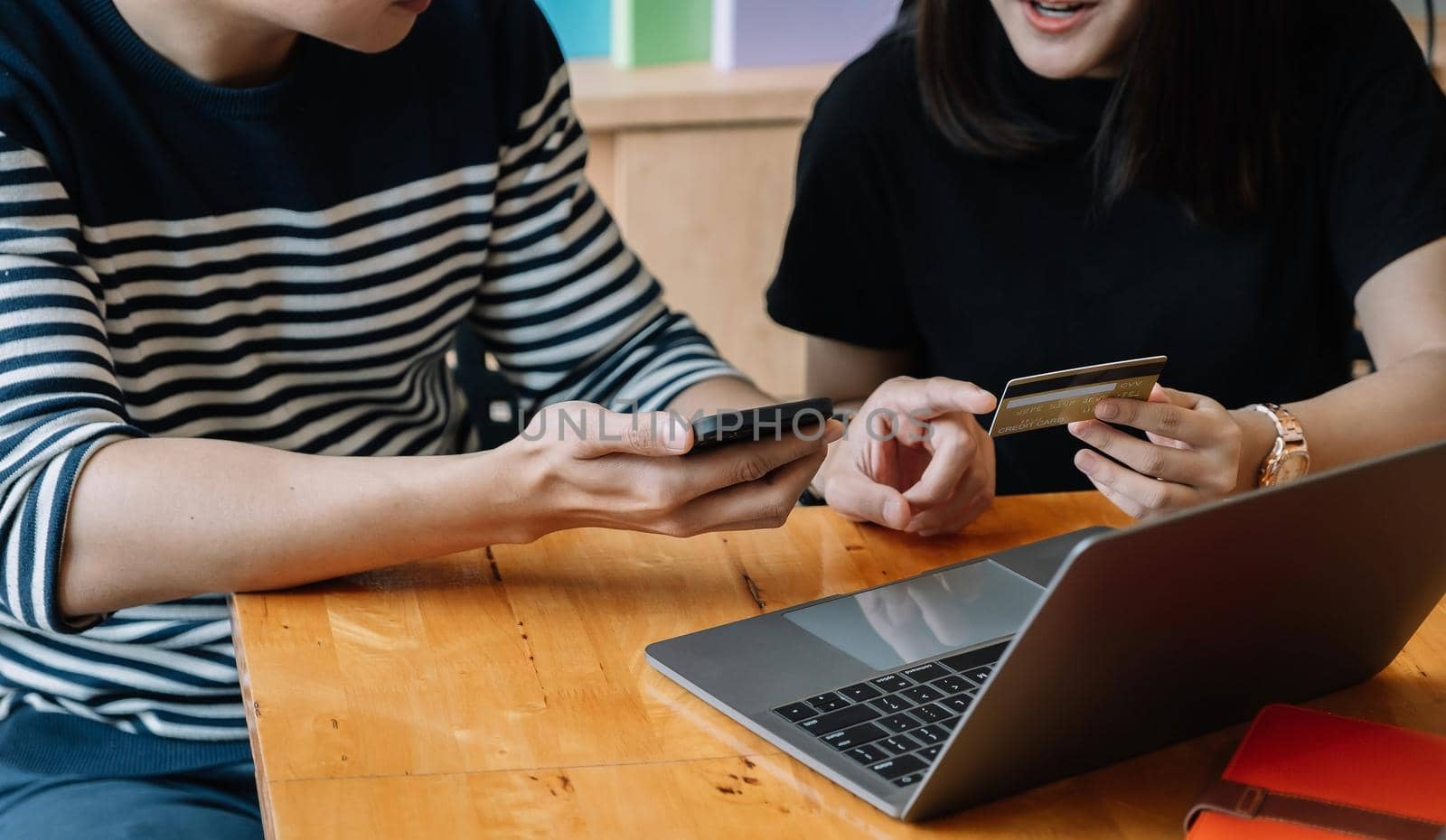 Happy couple shopping online with smartphone laptopn and creditcard at home.