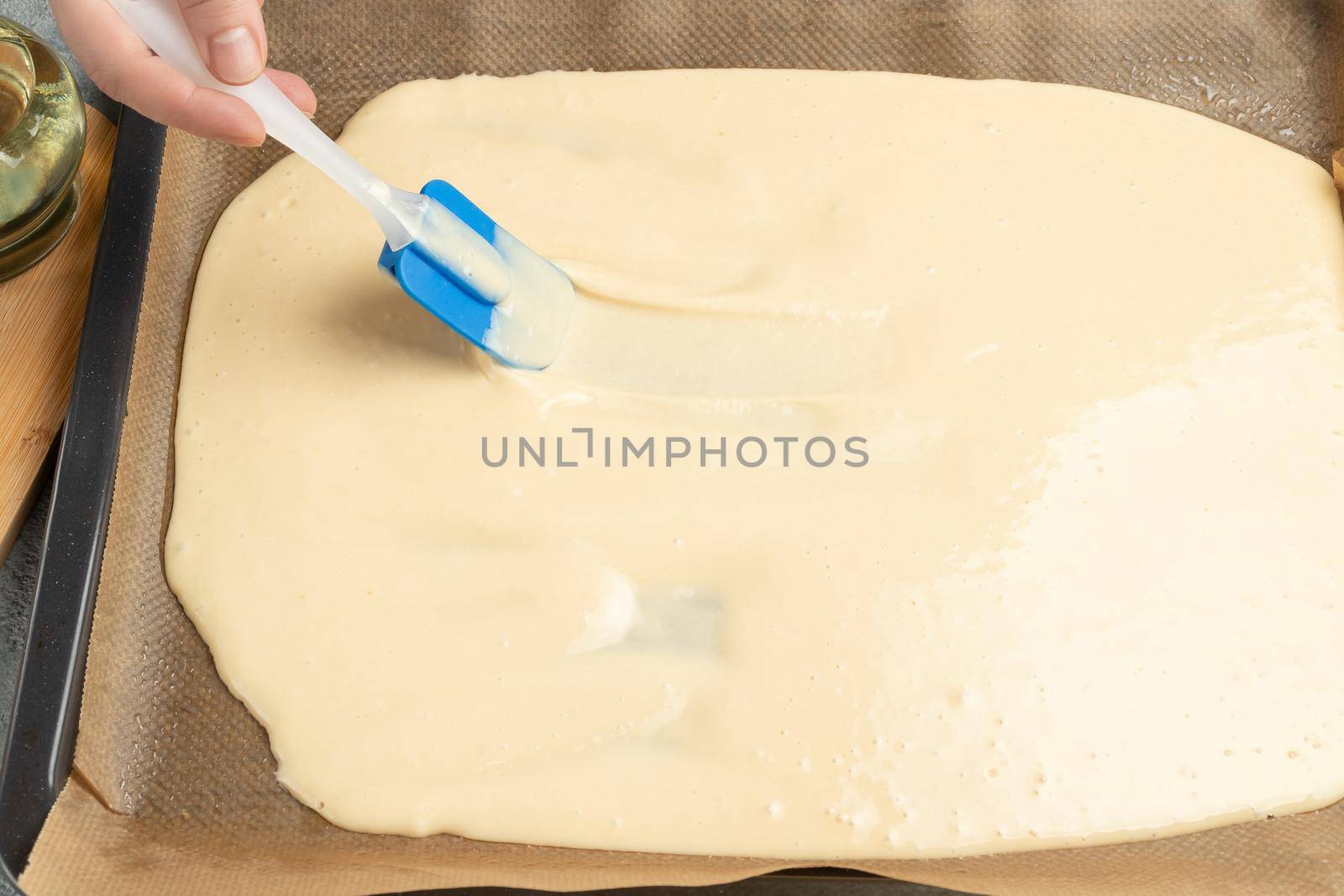 Spreading the dough for the sweet roll on a baking sheet.