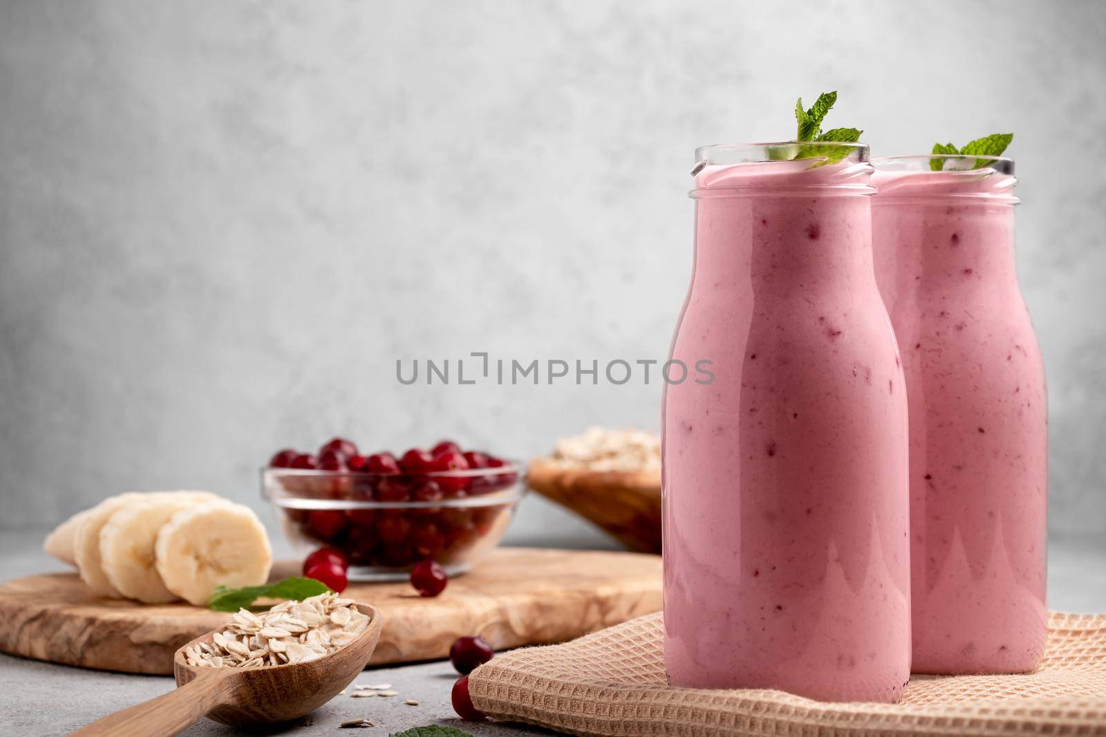 Homemade yogurt smoothie with banana, cranberry and oatmeal, copy space.