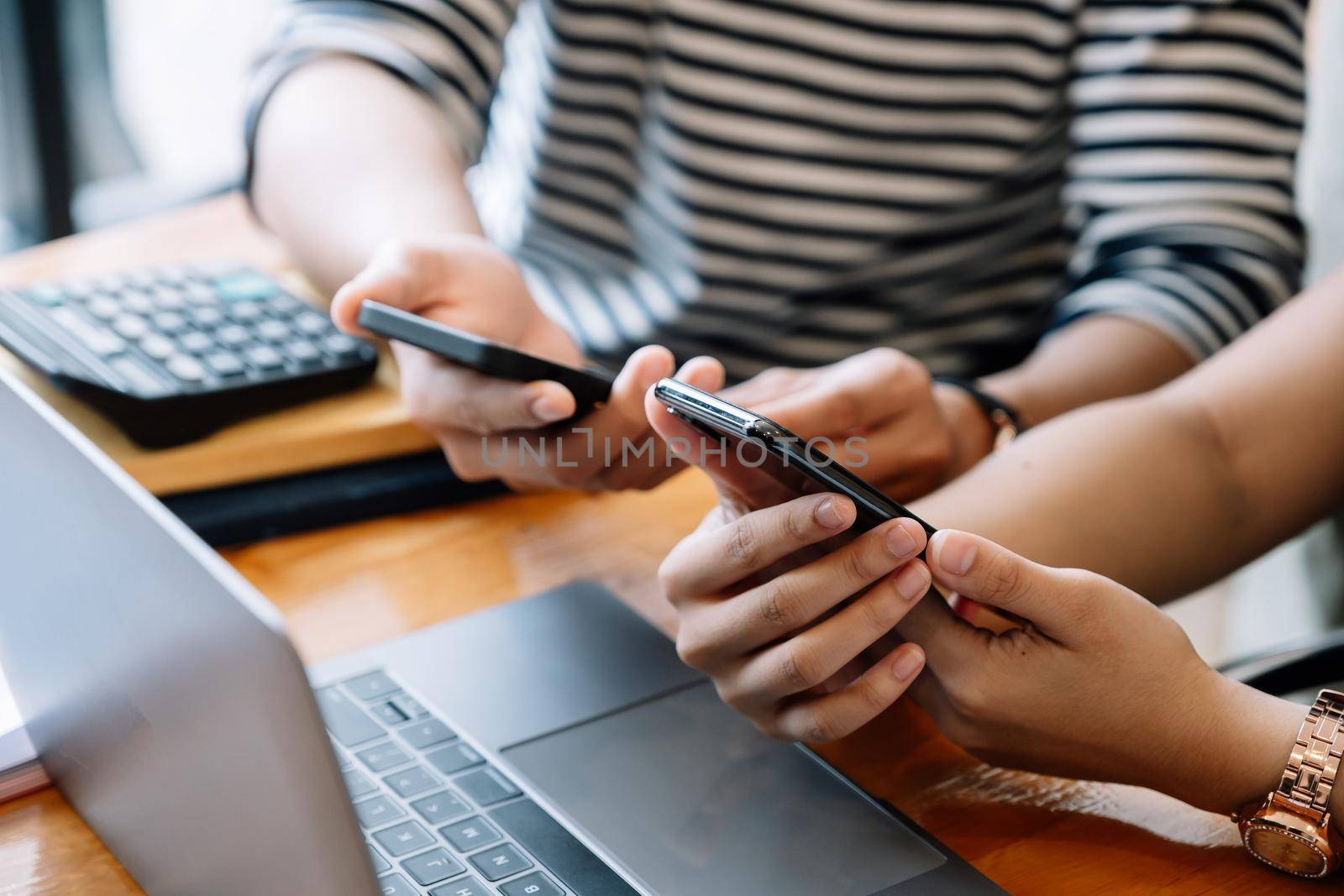 Group of young people using and looking at mobile phone while sitting together.