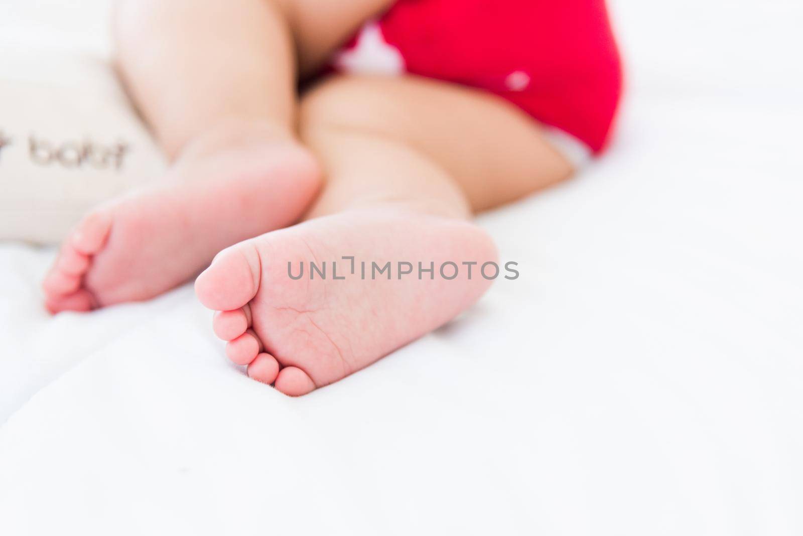 newborn little baby sleeping on white bed at home by Sorapop