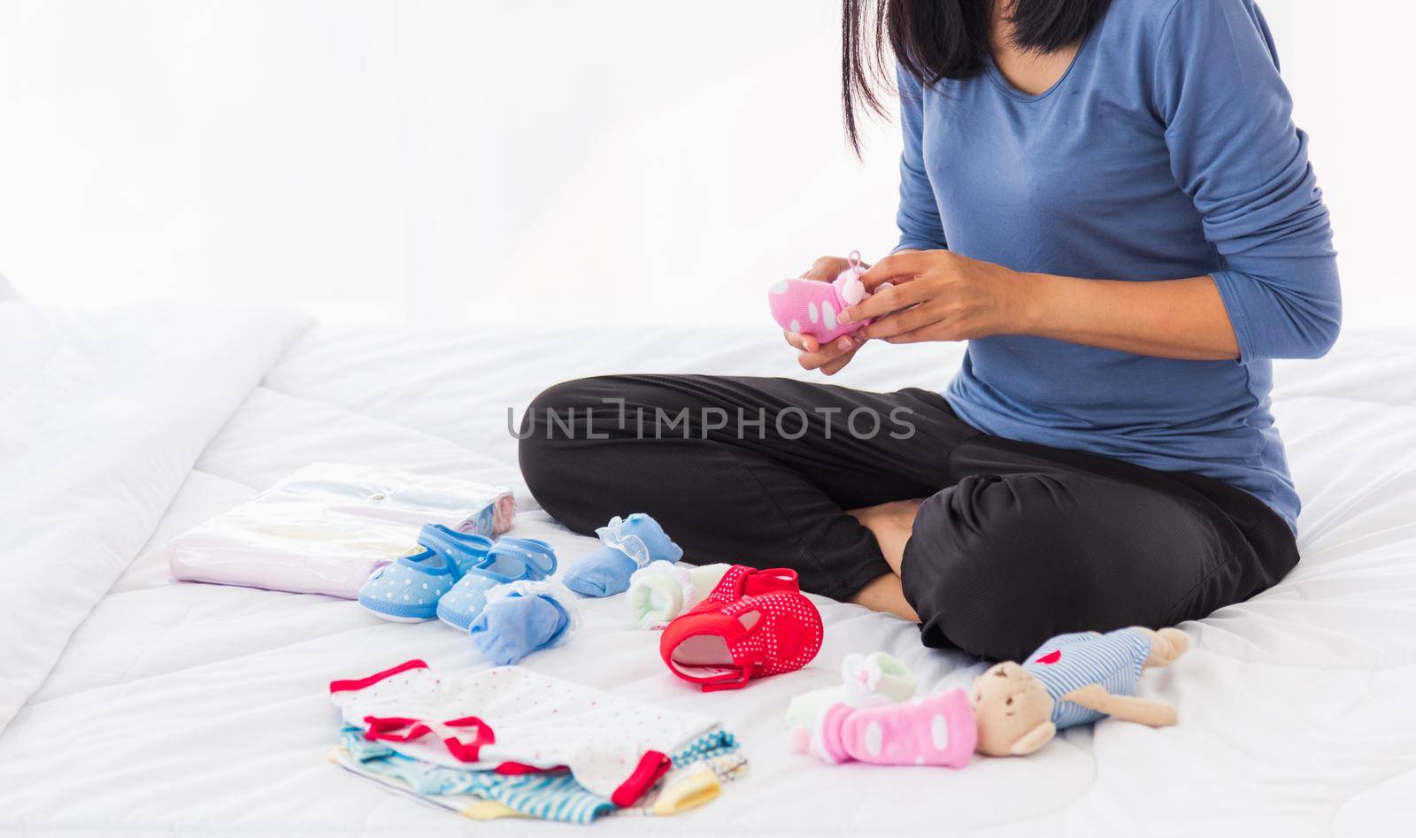 mother preparing baby clothes resting and relaxing on the bed by Sorapop