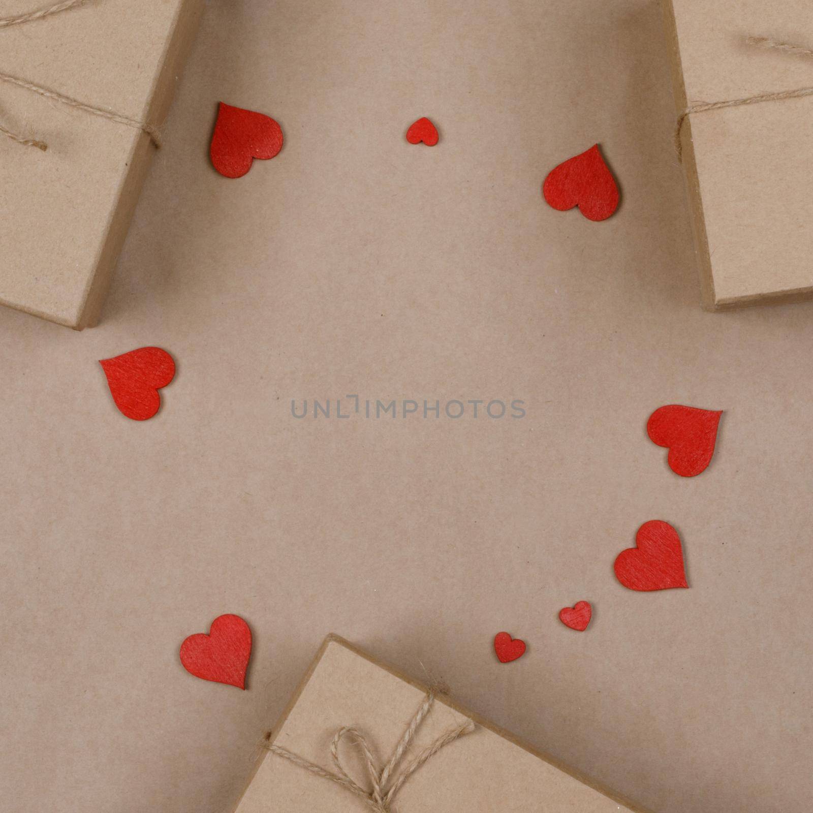 Boxes with gifts wrapped in brown craft paper and red paper hearts Valentines day concept