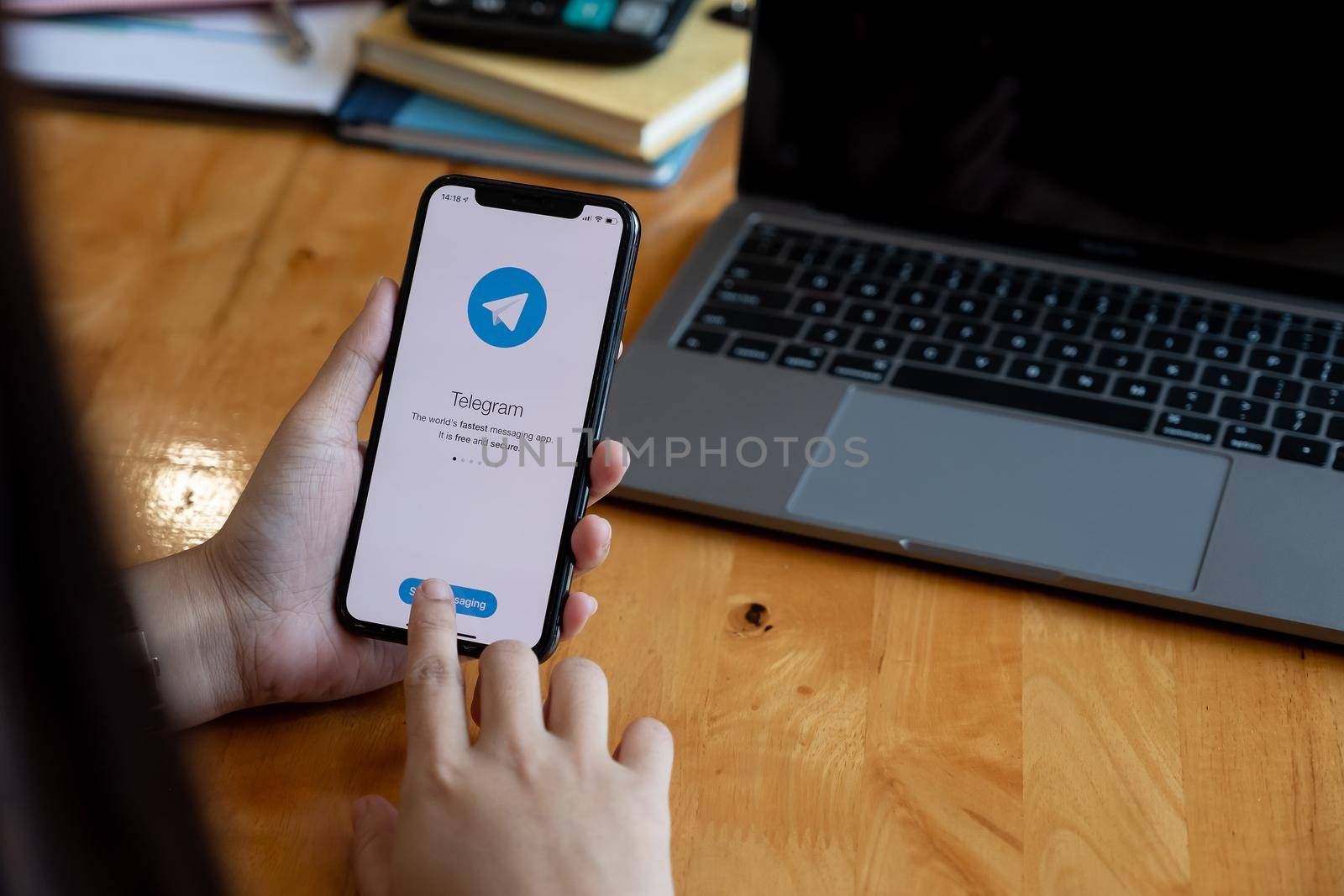 CHIANG MAI, THAILAND, JAN 23, 2021 : Woman hand holding iPhone with social networking service Telegram on the screen. iPhone 12 was created and developed by the Apple inc