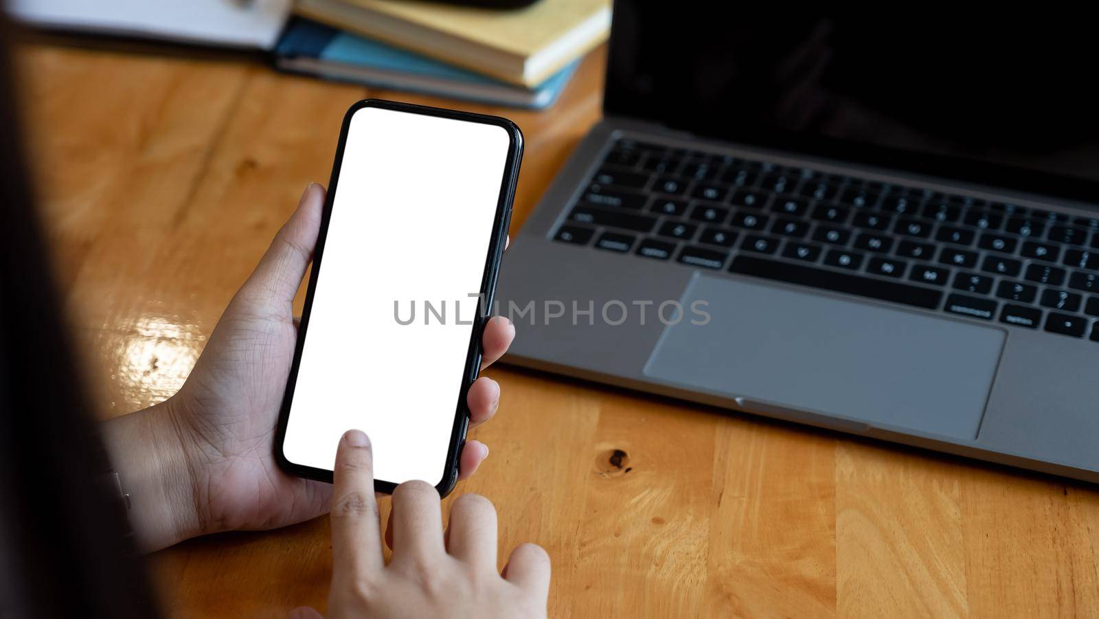 Woman holding and touch smartphone blank screen in the mall. Take your screen to put on advertising.