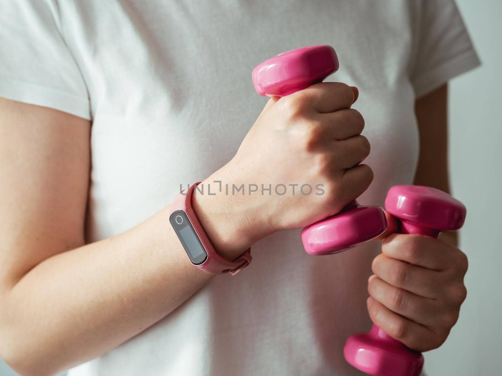 Woman with fitness tracker and barbells by fascinadora