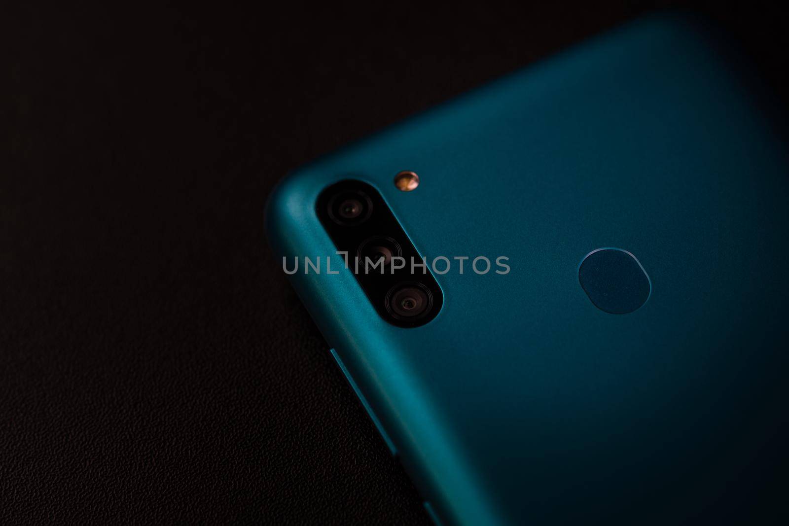 Selective focus on back of new smartphone Samsung Galaxy M11 triple camera and fingerprint sensor. Bucharest, Romania, 2021