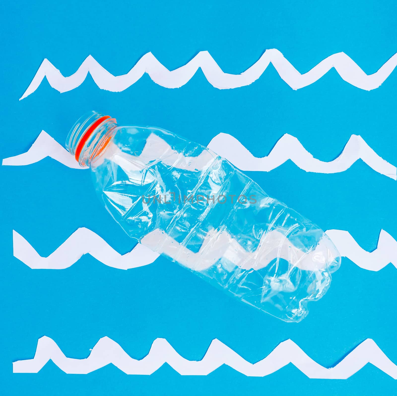a plastic bottle floats on a surface that represents the sea
