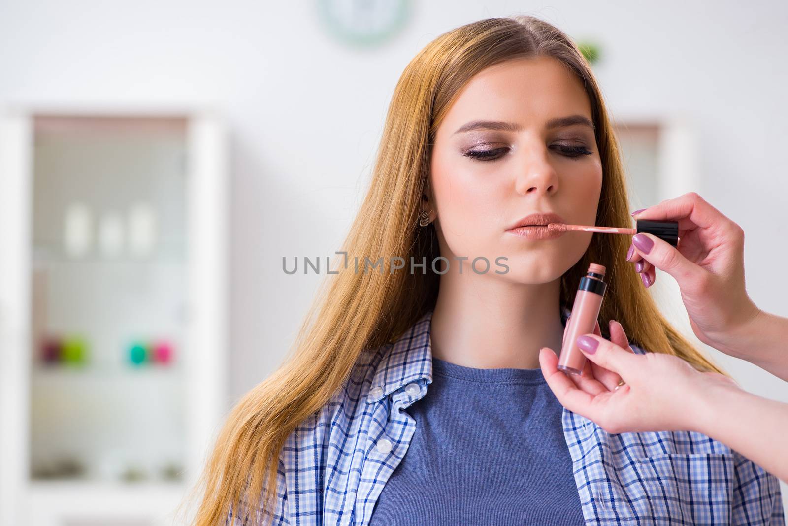Woman getting her make-up done in beauty salon by Elnur