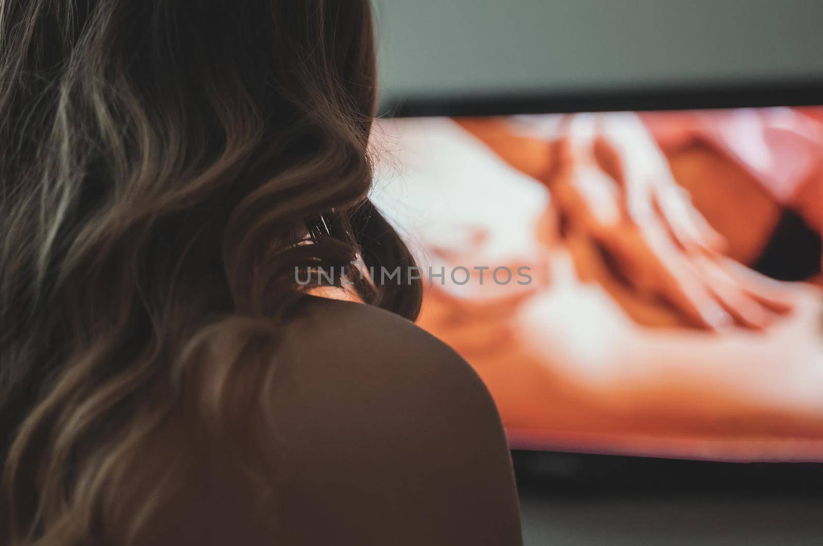 Woman watching erotic film on TV.