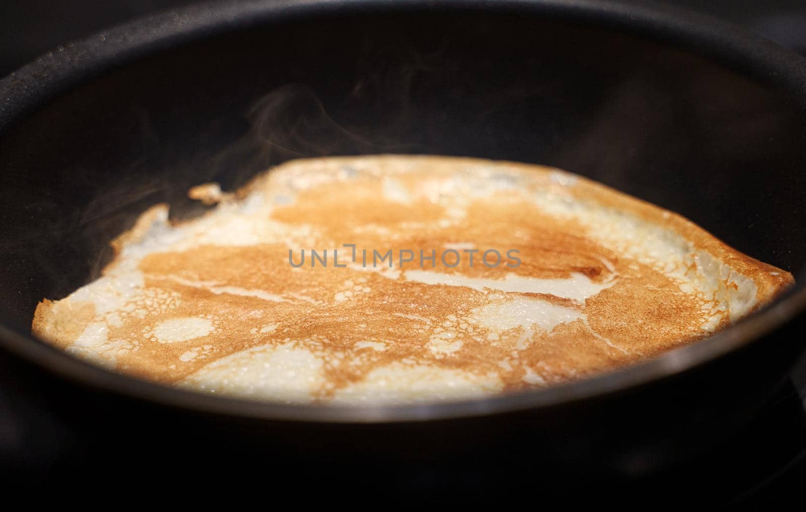 Pancake on frying pan. Making of pancakes.