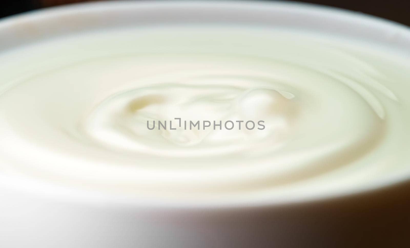 Milk drop falls into the filled cup. by dmitrimaruta