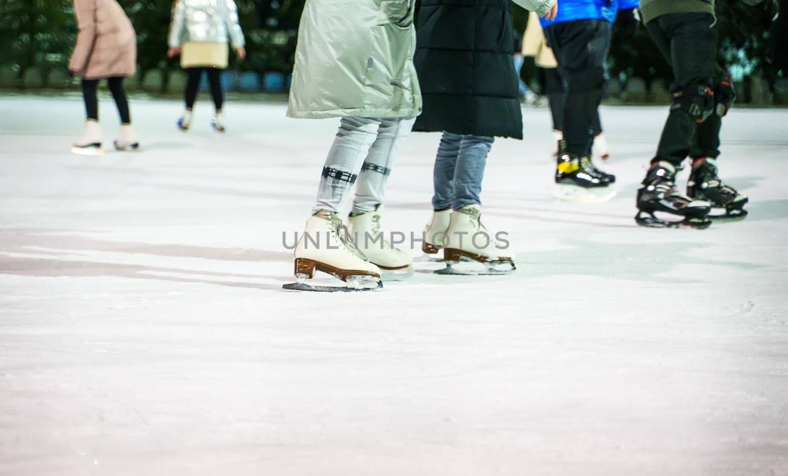 People ice skating on the ice rink in winter. by dmitrimaruta