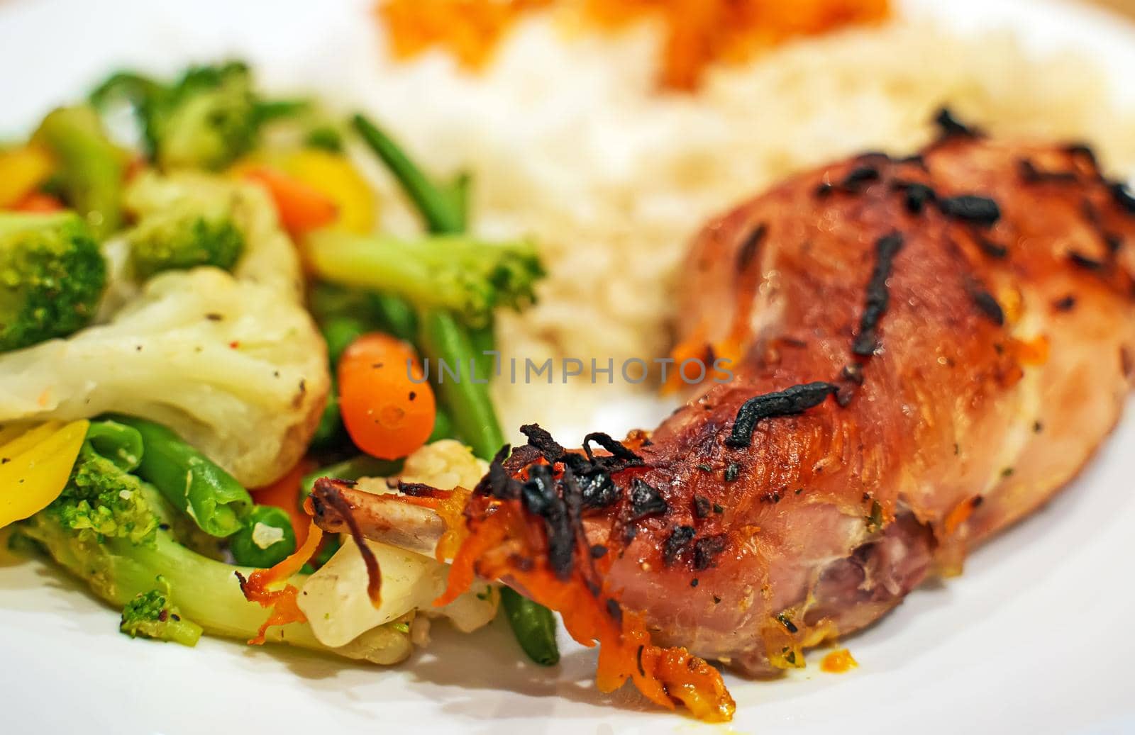 Baked rabbit leg with rice and vegetables.