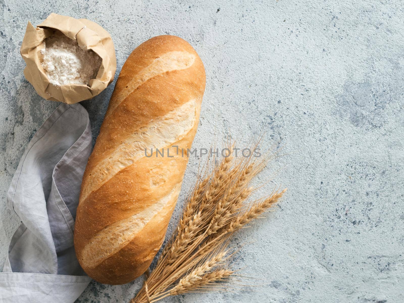 British White Bloomer or European Baton loaf bread on white marble background. Top view or flat lay. Copy space for text or design.