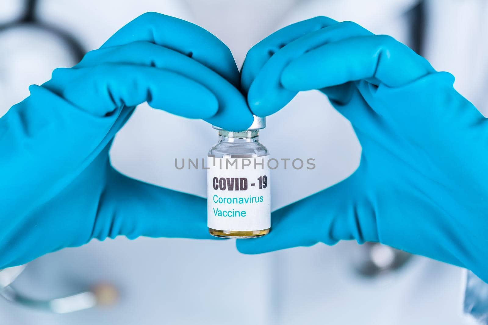 Woman doctor or nurse in uniform and gloves wearing face mask protective in lab holding in a form of heart medicine vial vaccine bottle with COVID-19 Coronovirus vaccine label