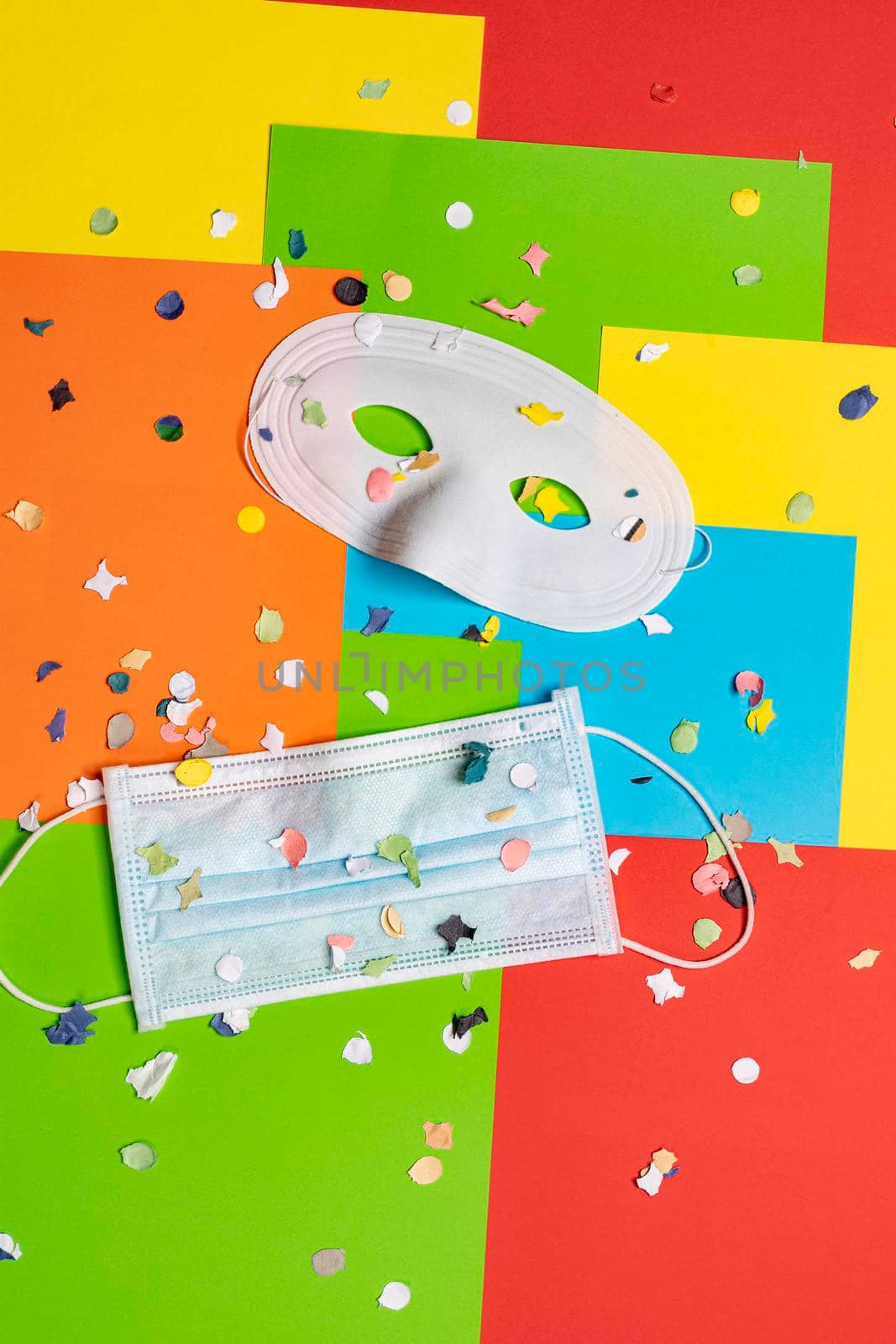 masks, confetti, treamers and mask on a colorful carnival table during Covid 19 pandemic