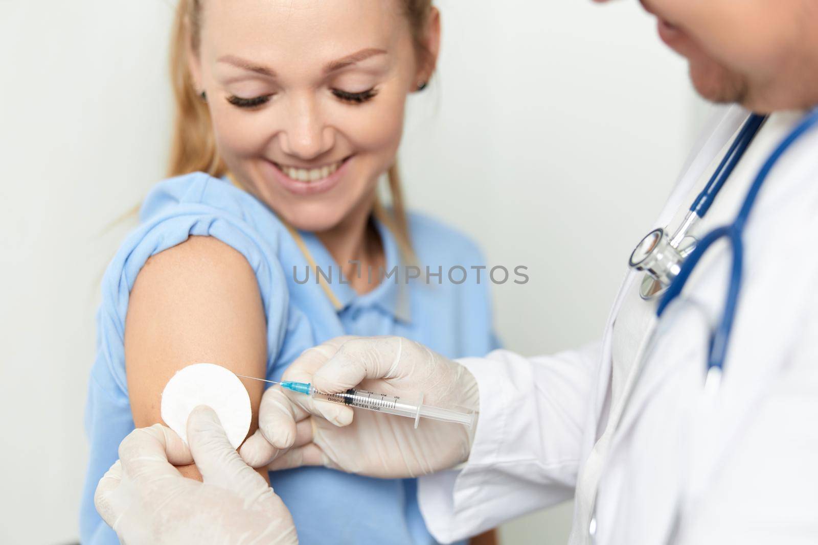 doctor giving an injection to a woman health covid vaccination by SHOTPRIME