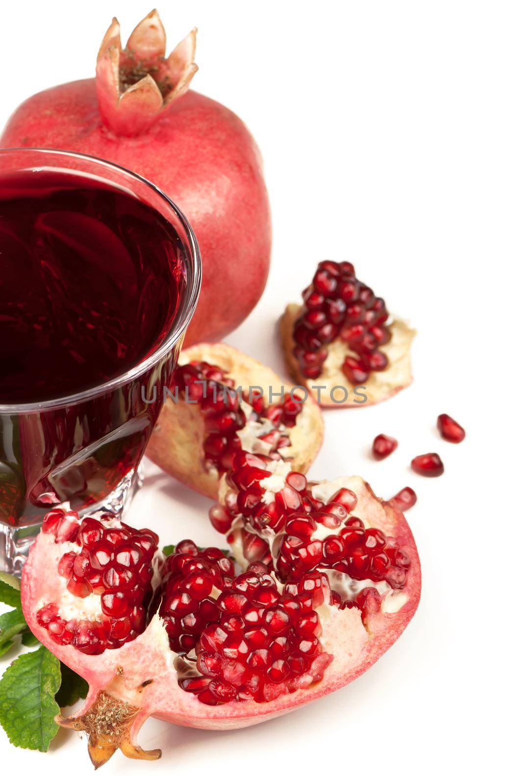 Ripe pomegranates with juice on a white background by aprilphoto