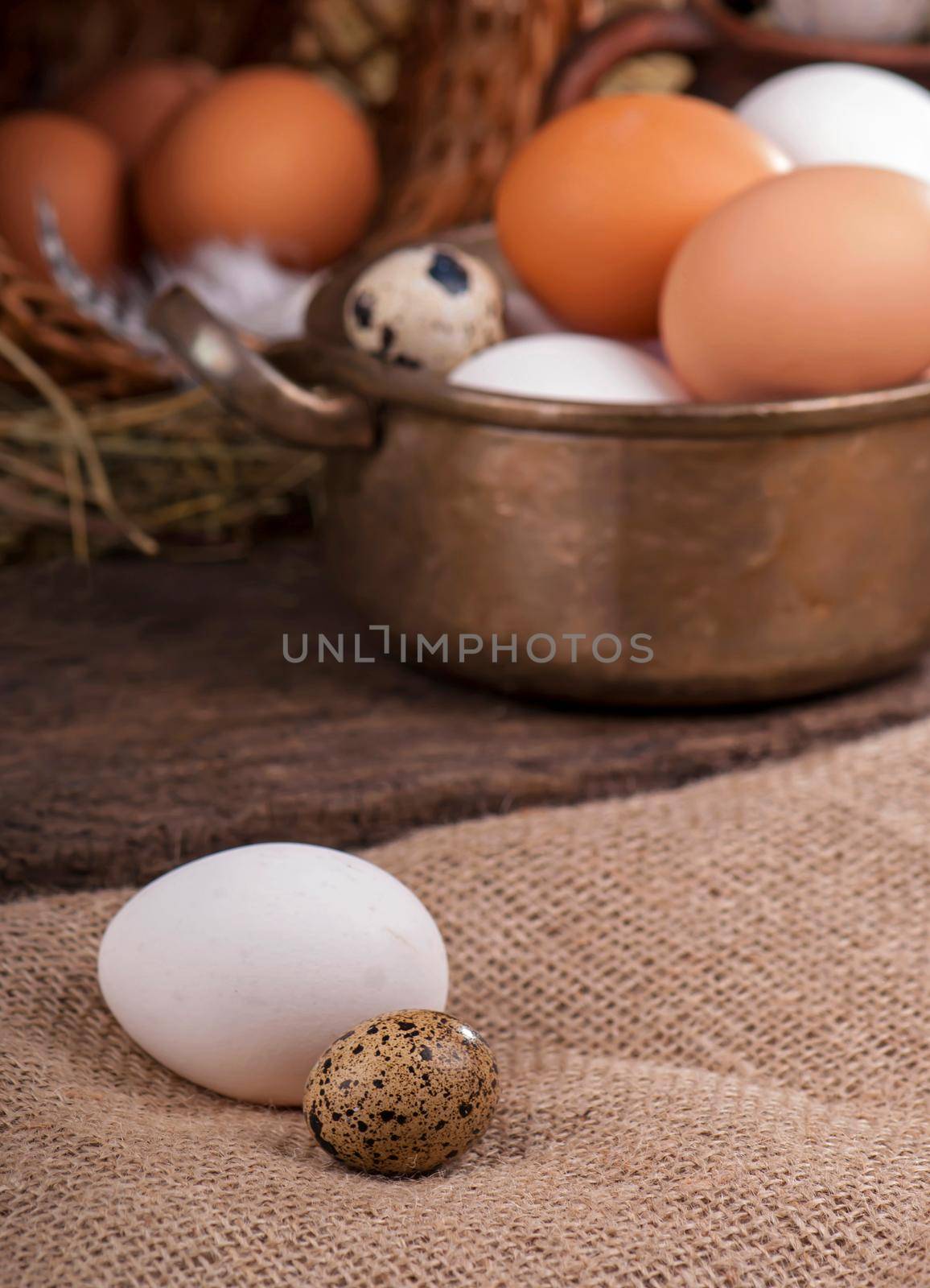Brown eggs in wooden basket. Broken egg with yolk in background.