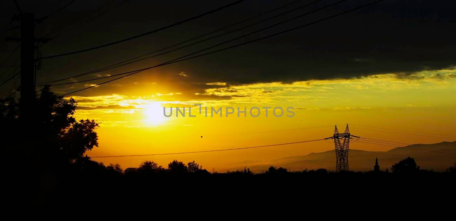 Sunrise background with power pylon and cables silhouettes