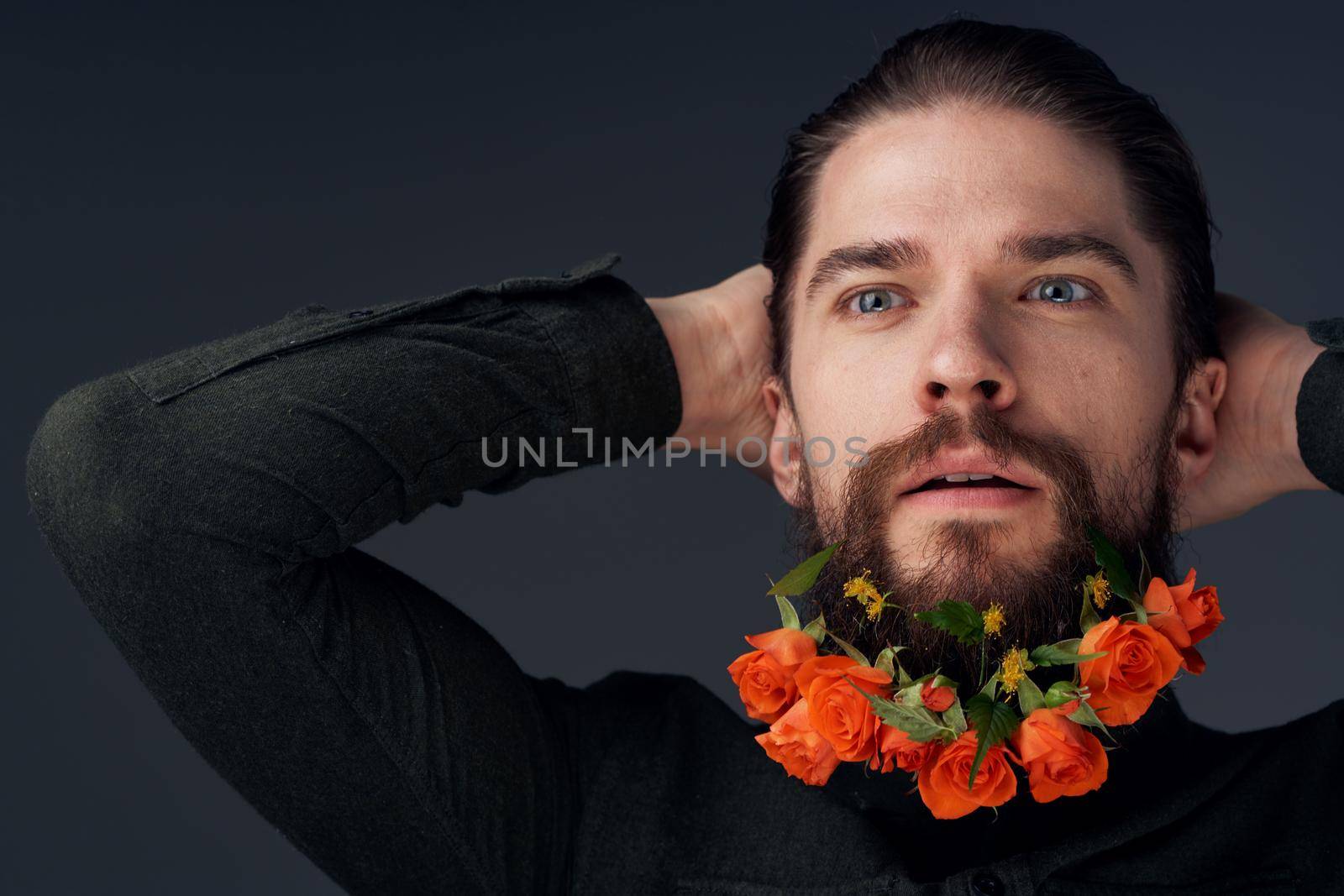 man flowers decoration in beard emotions black background. High quality photo