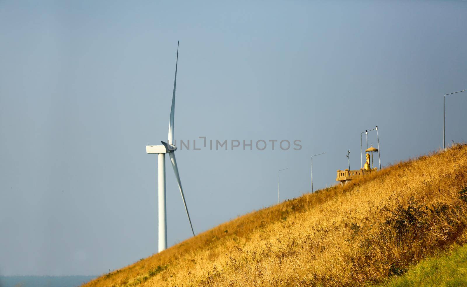 Wind power station. Wind generators stand in agricultural fields on mountain. Wonderful landscape shot from a great height. Modern green energy.