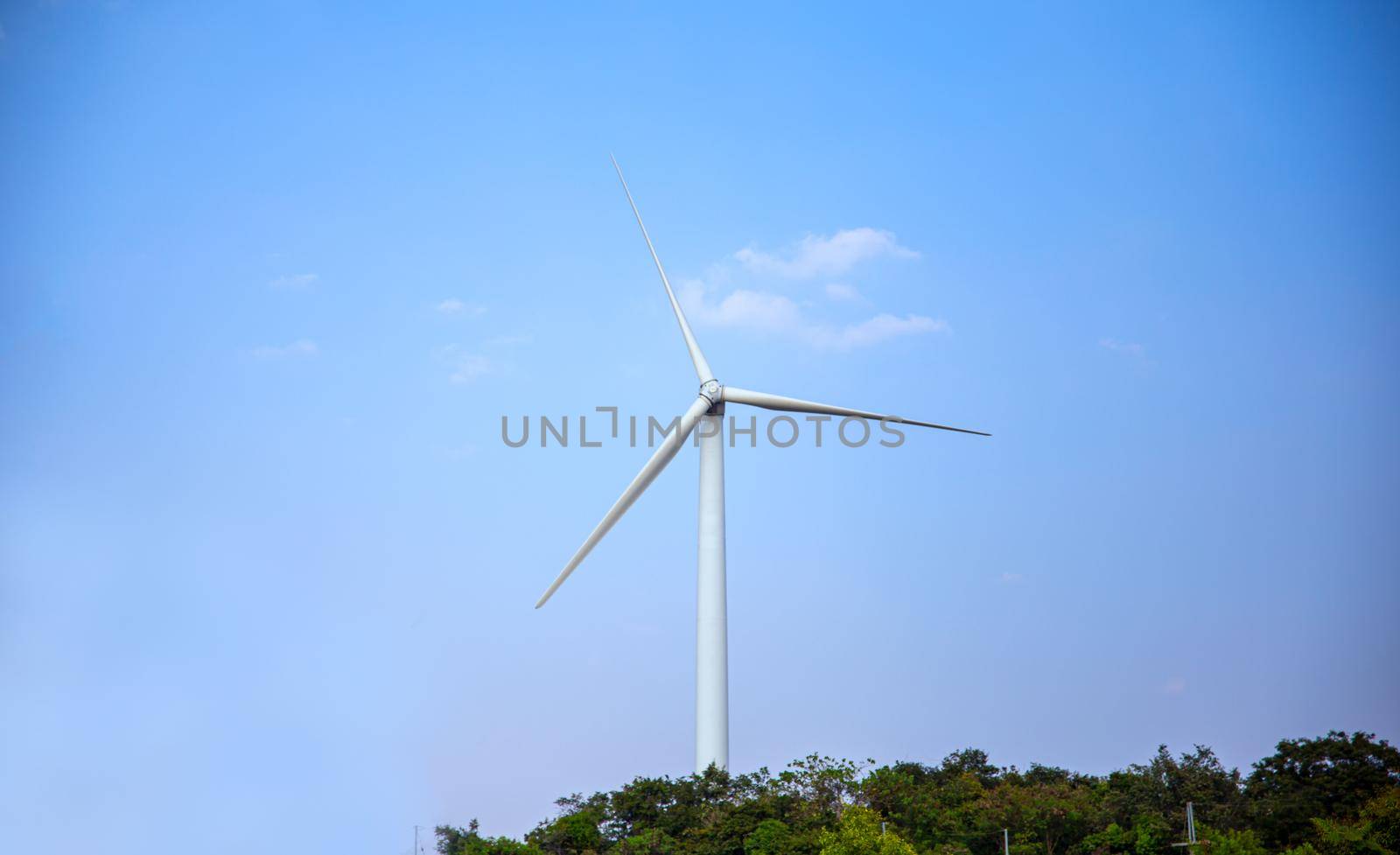 Wind power station. Wind generators stand in agricultural fields on mountain. Wonderful landscape shot from a great height. Modern green energy.