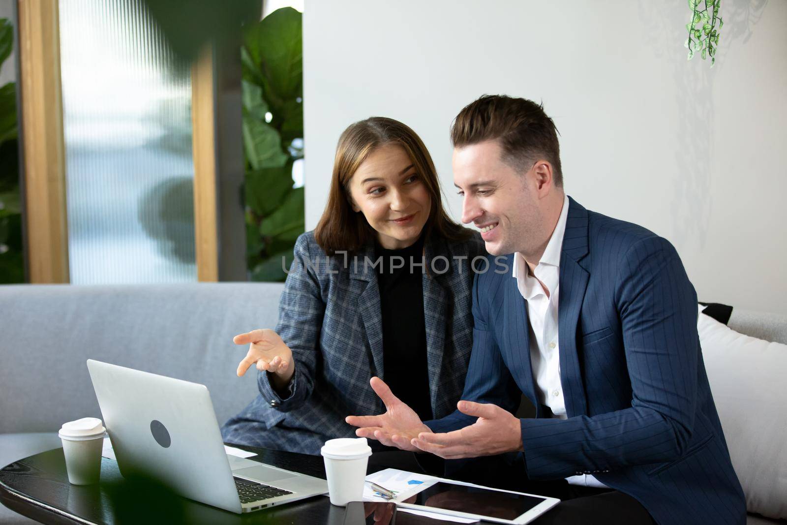 Business people talking in office using digital tablet and computer 