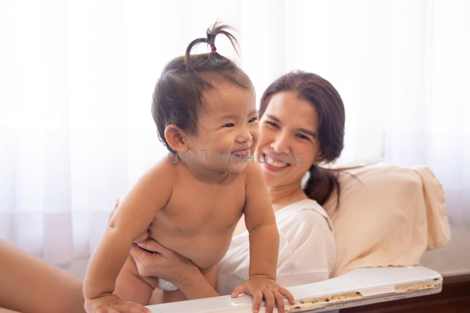 Loving and affectionate mother holding newborn baby indoors at home.