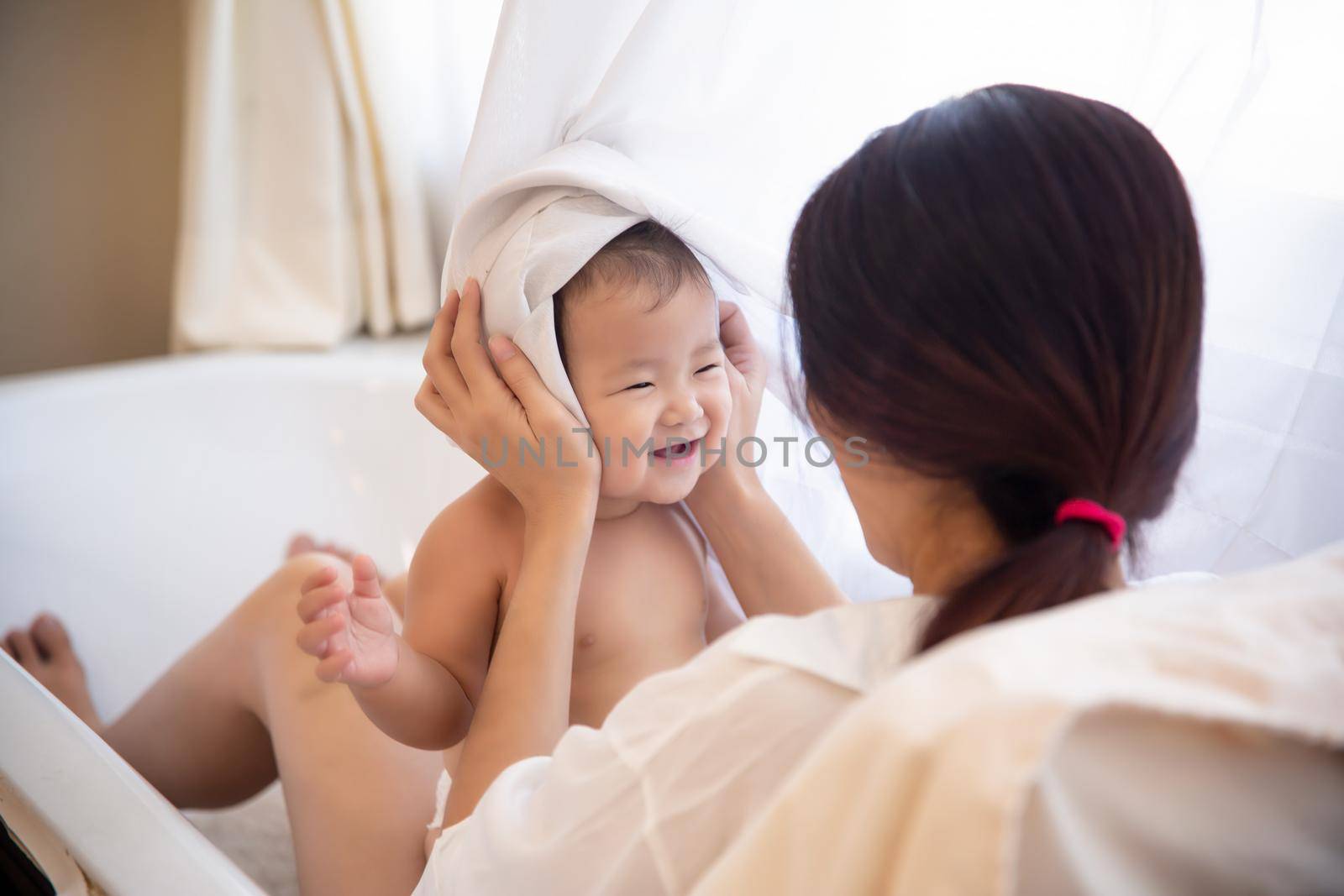 Loving and affectionate mother holding newborn baby indoors at home.