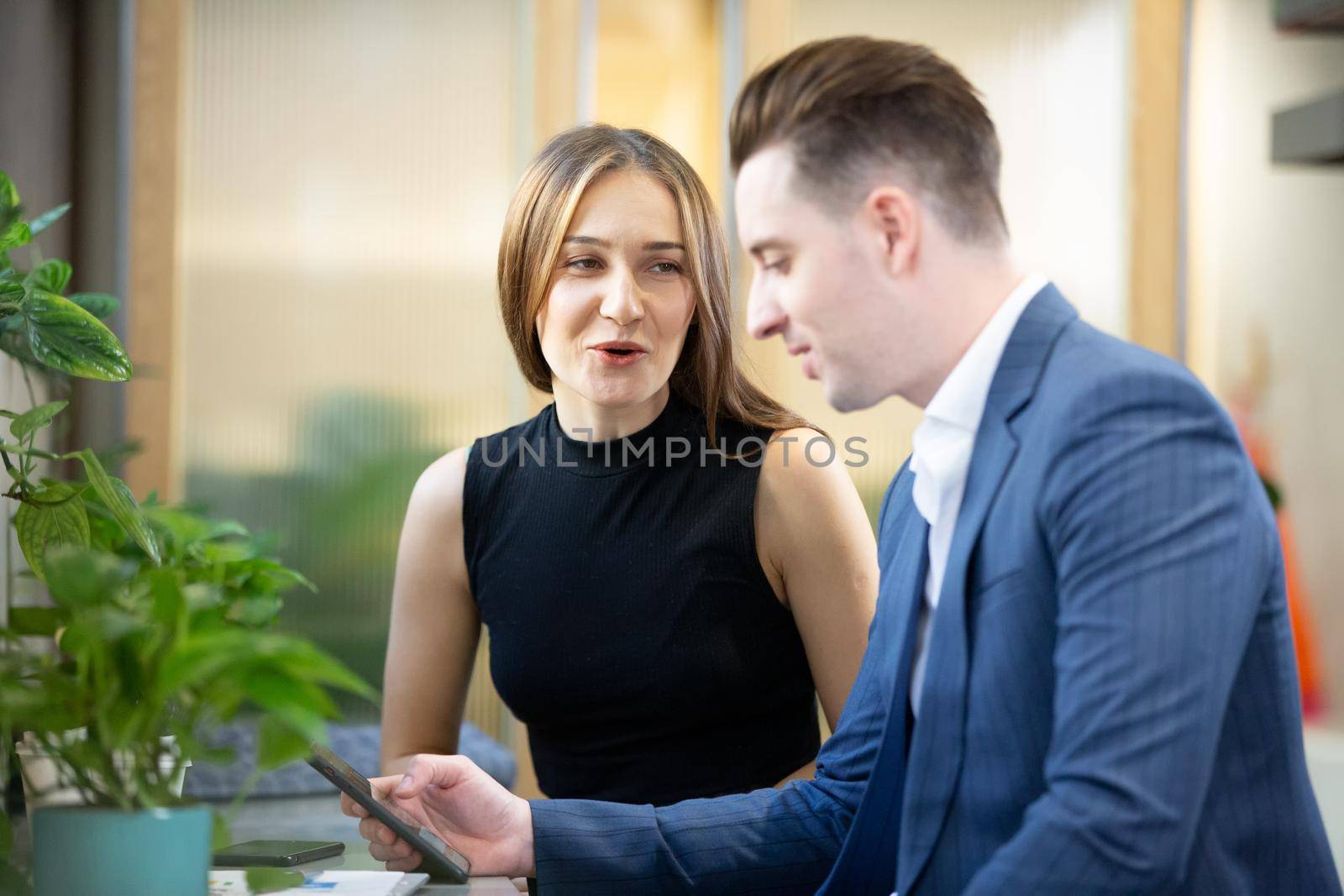 Business people talking in office using digital tablet and computer 