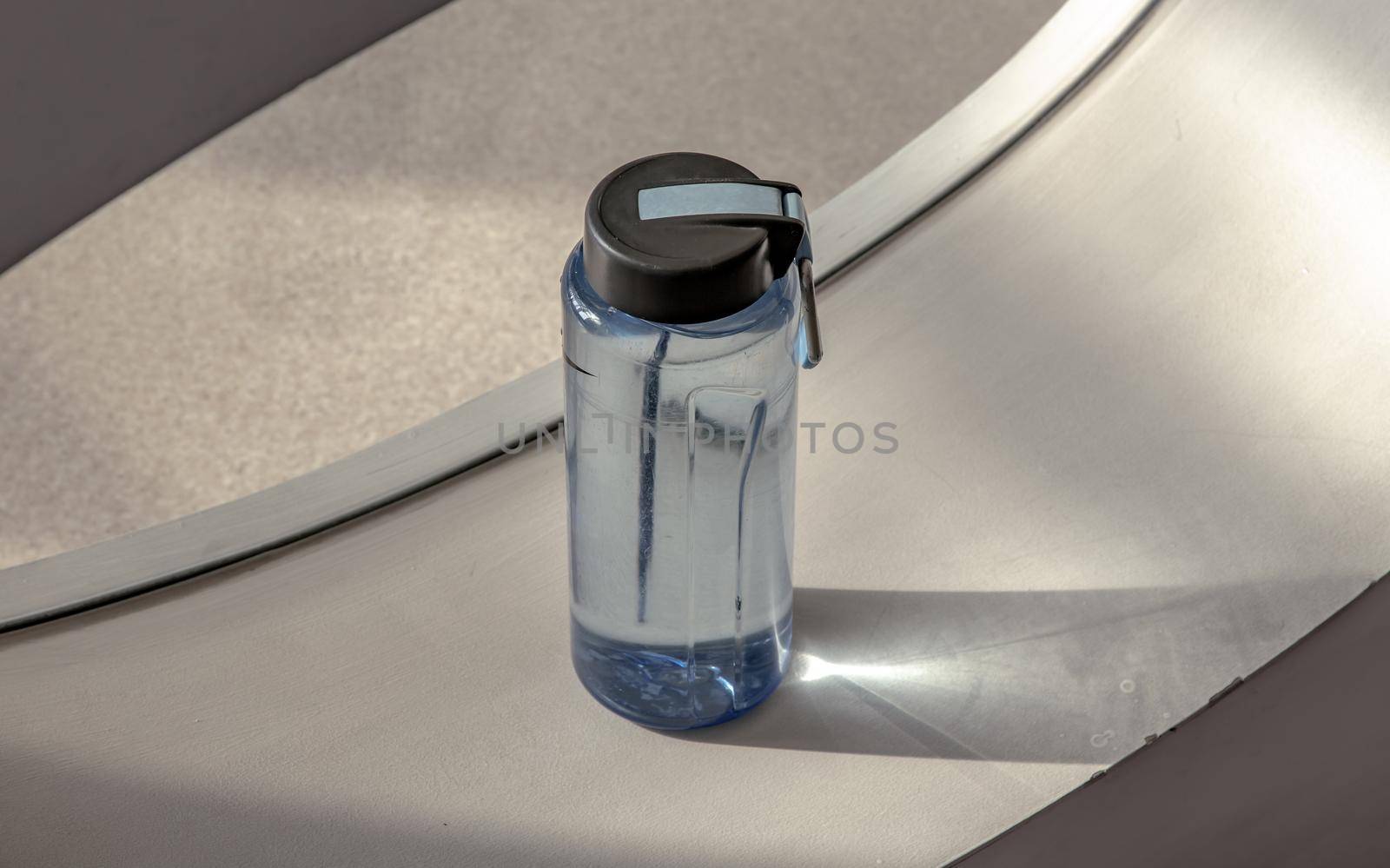 Sport water bottle in sport club or gym and fitness room with free space. Gym concept. Selective focus.