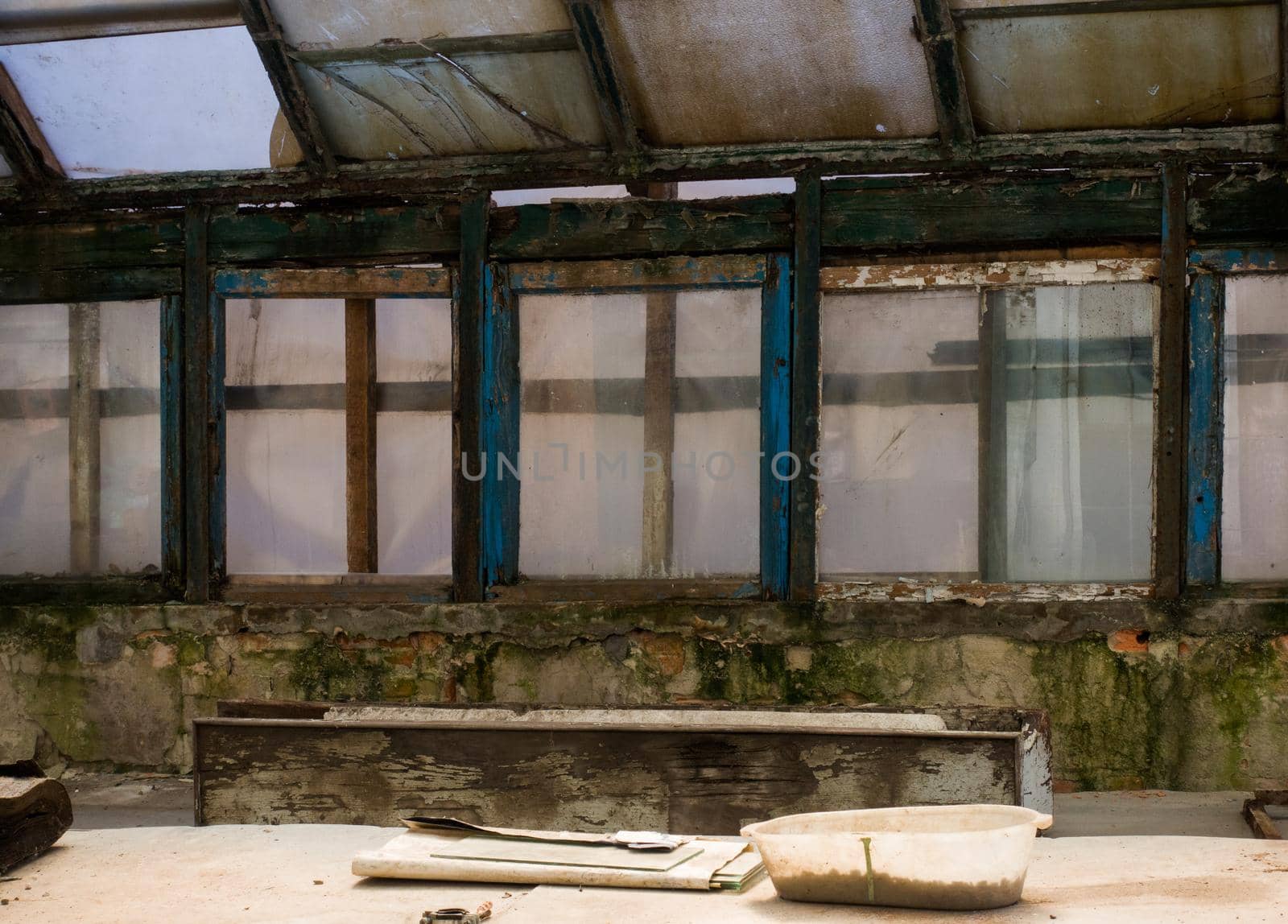 Inside the old room. Abandoned room with dirty windows. An old greenhouse.