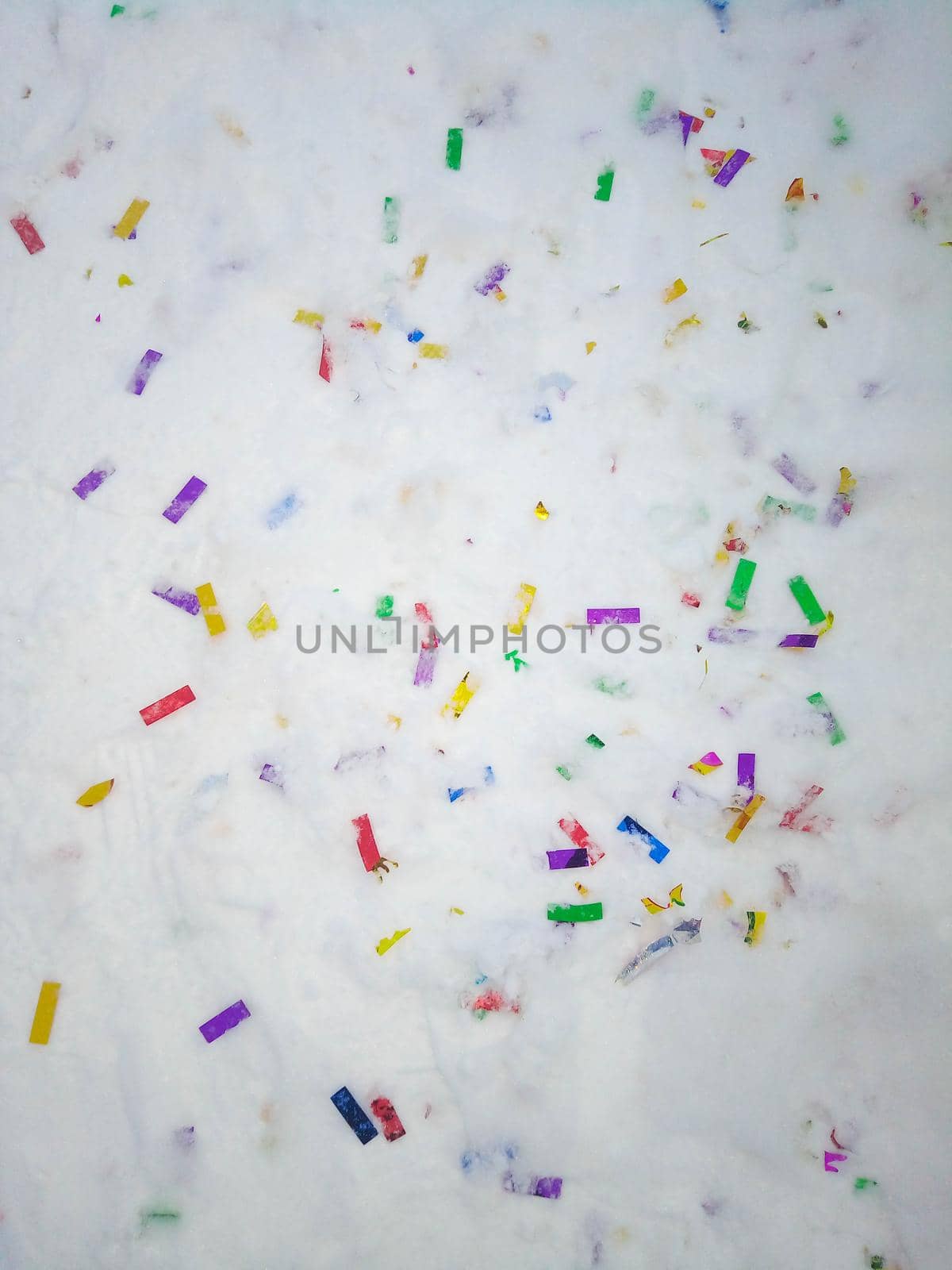 Colorful confetti glitter on the snow after holiday. No plastic, eco living concept.