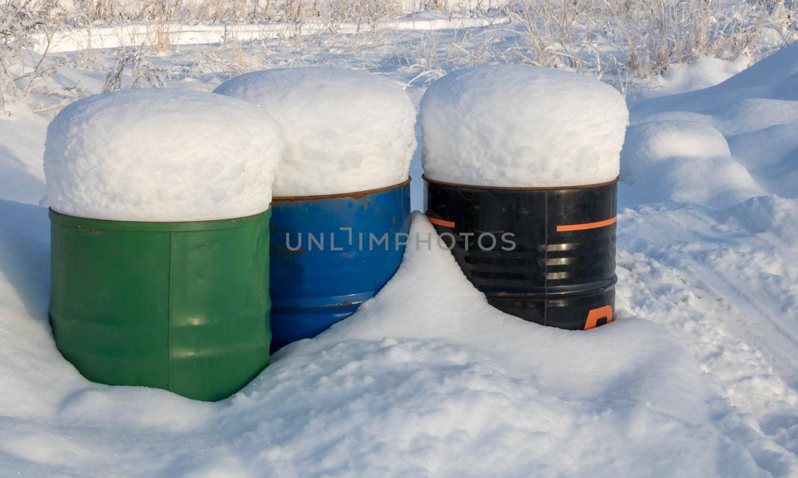 Frozen crumpled red barrel in the snow.