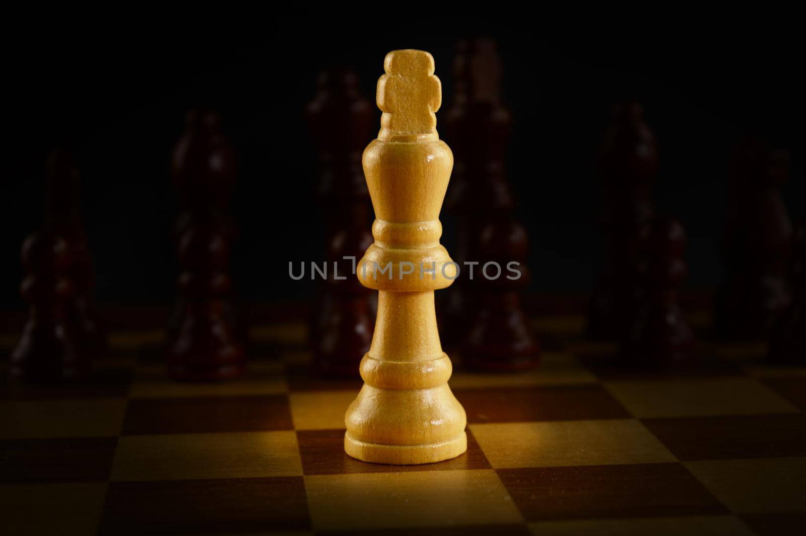 A Chess game board with a spotlighted King against the opponents army.