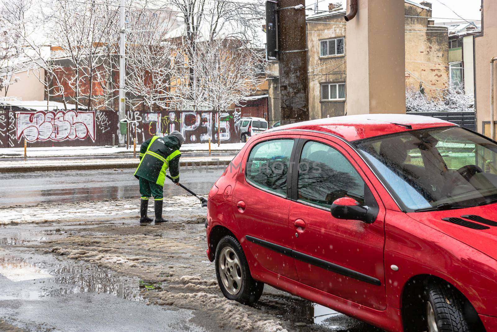 Snow removal, worker cleaning the snowy road in Bucharest, Romania, 2021