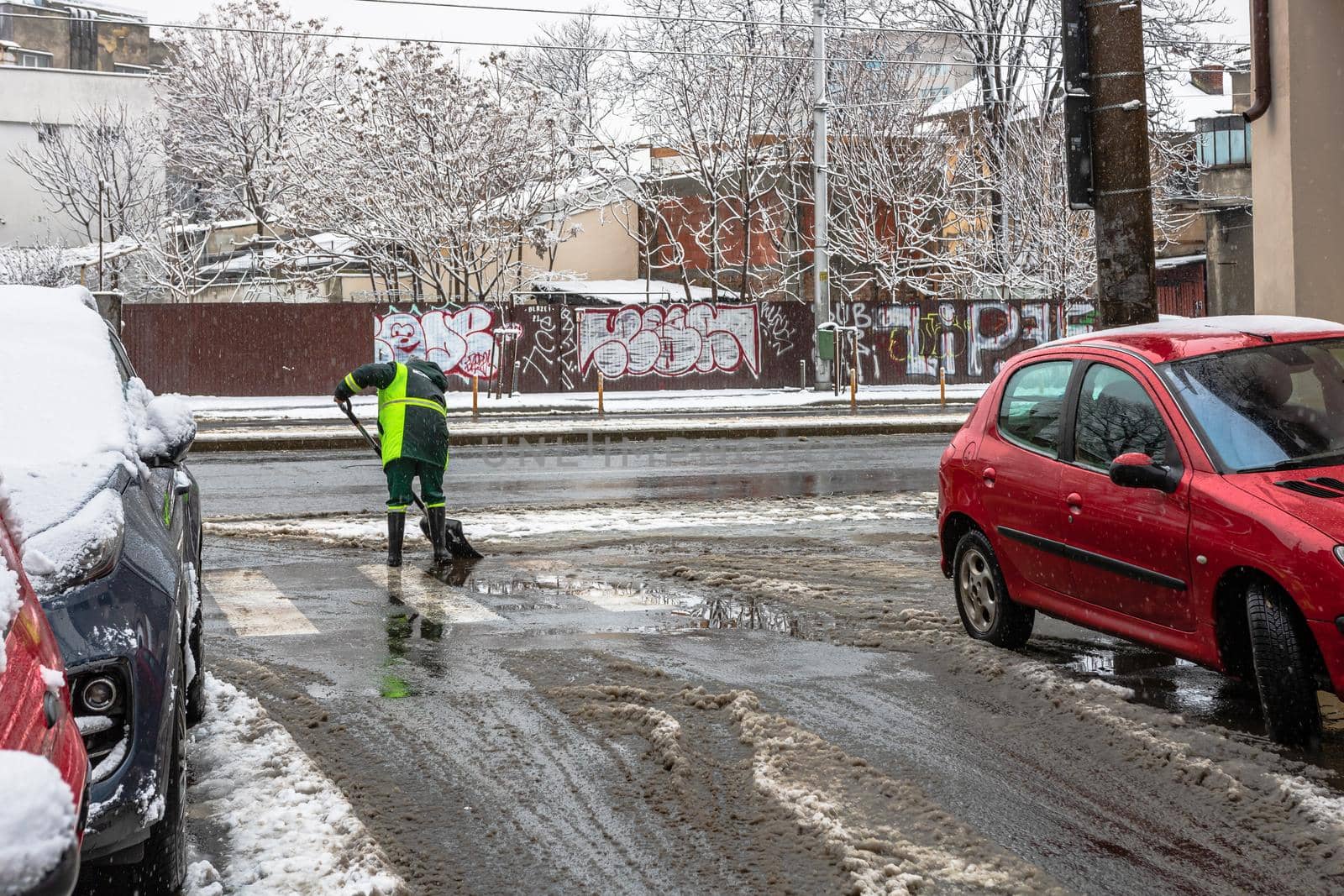 Snow removal, worker cleaning the snowy road in Bucharest, Romania, 2021