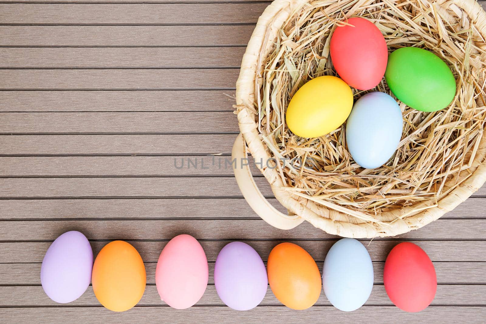 Close up Colorful easter eggs in the basket on wood background with space