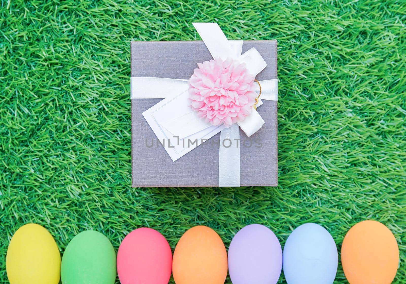 Easter eggs on grass and gift box by stoonn