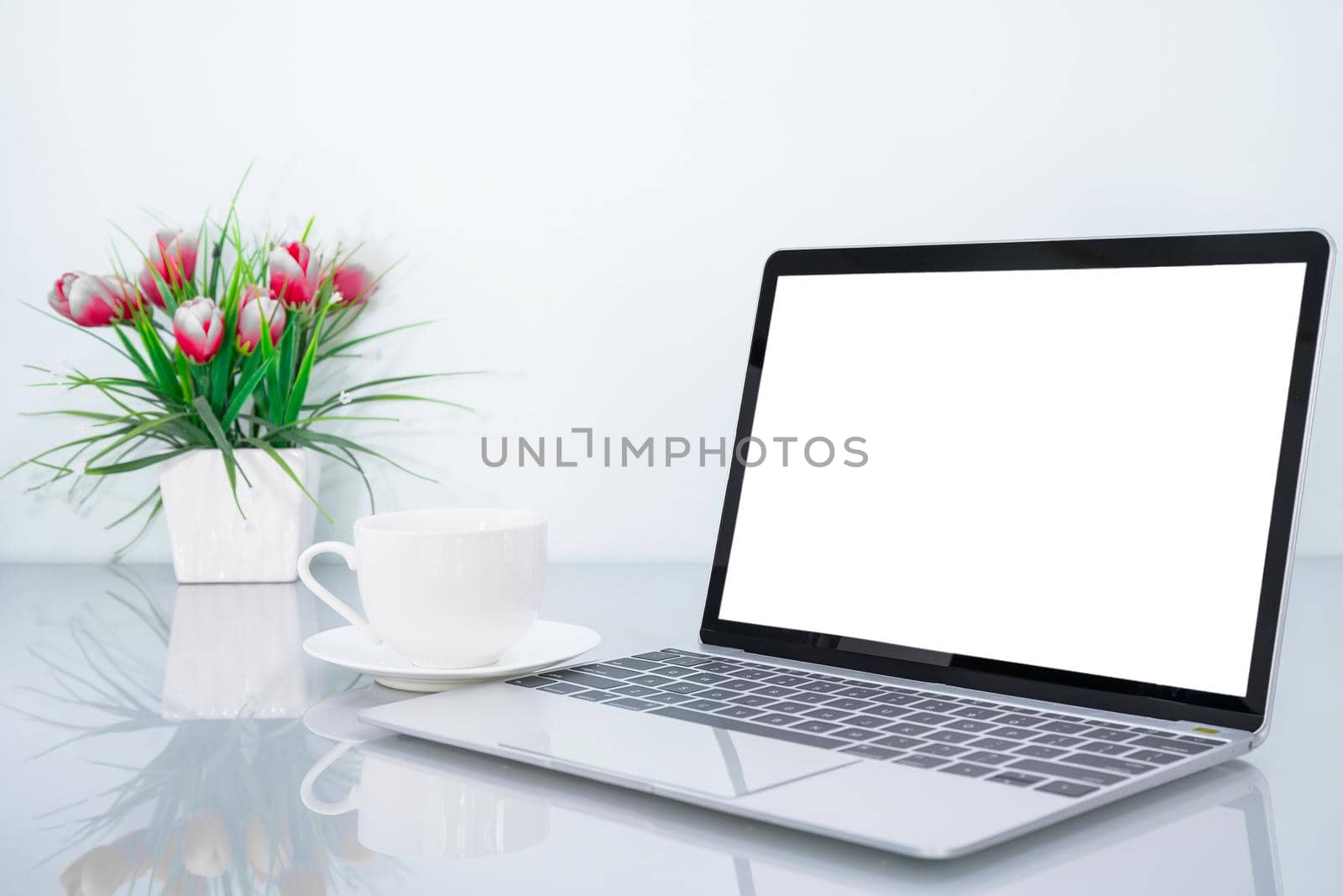 Laptop mockup with blank screen and book and flower on table