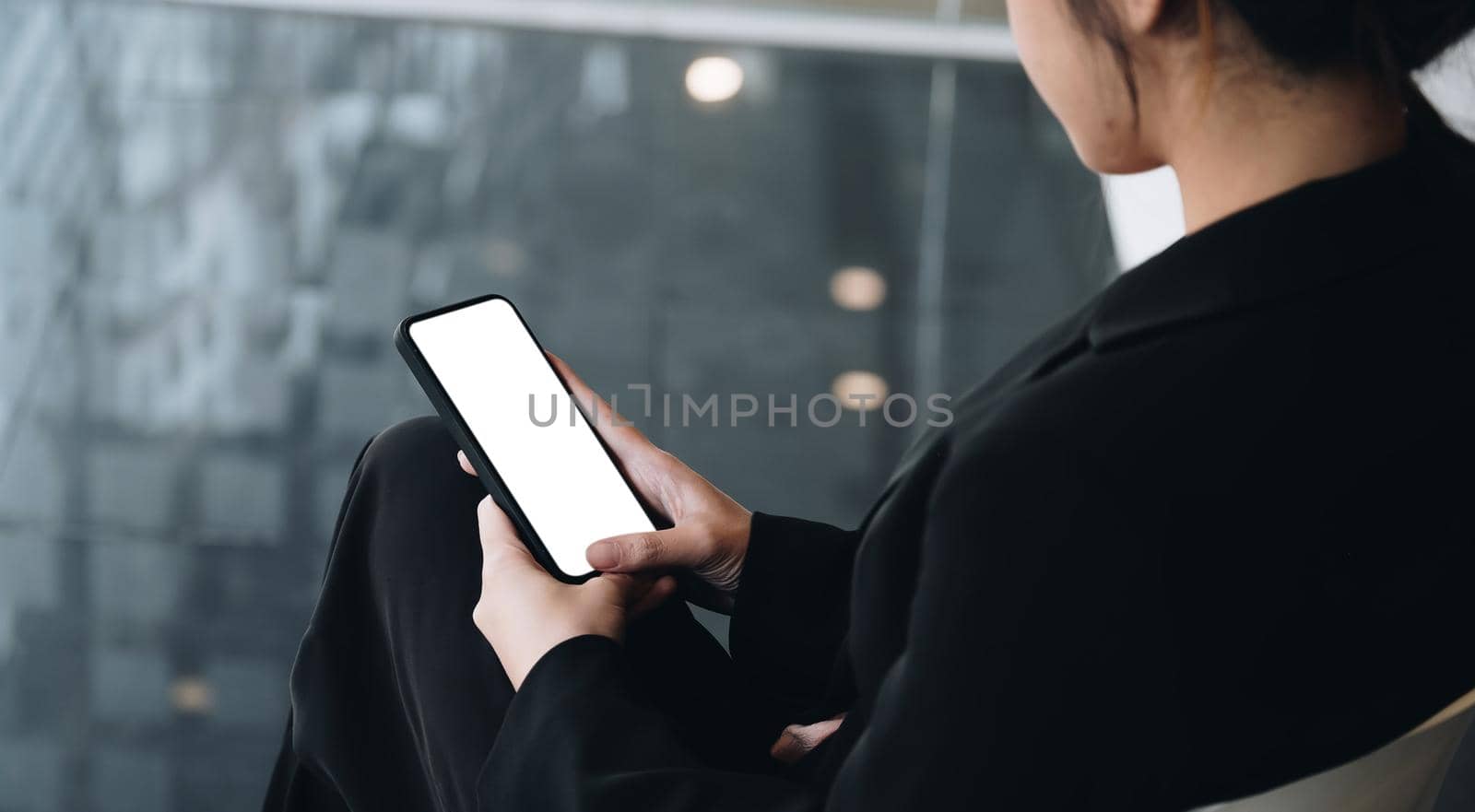 Businesswoman holding smart phone with white blank screen. For Graphic display montage by nateemee