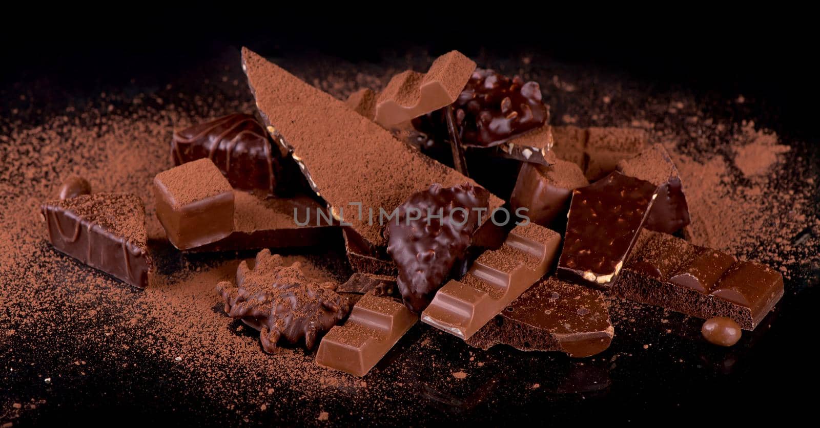 dark chocolate over wooden background, selective focus by aprilphoto